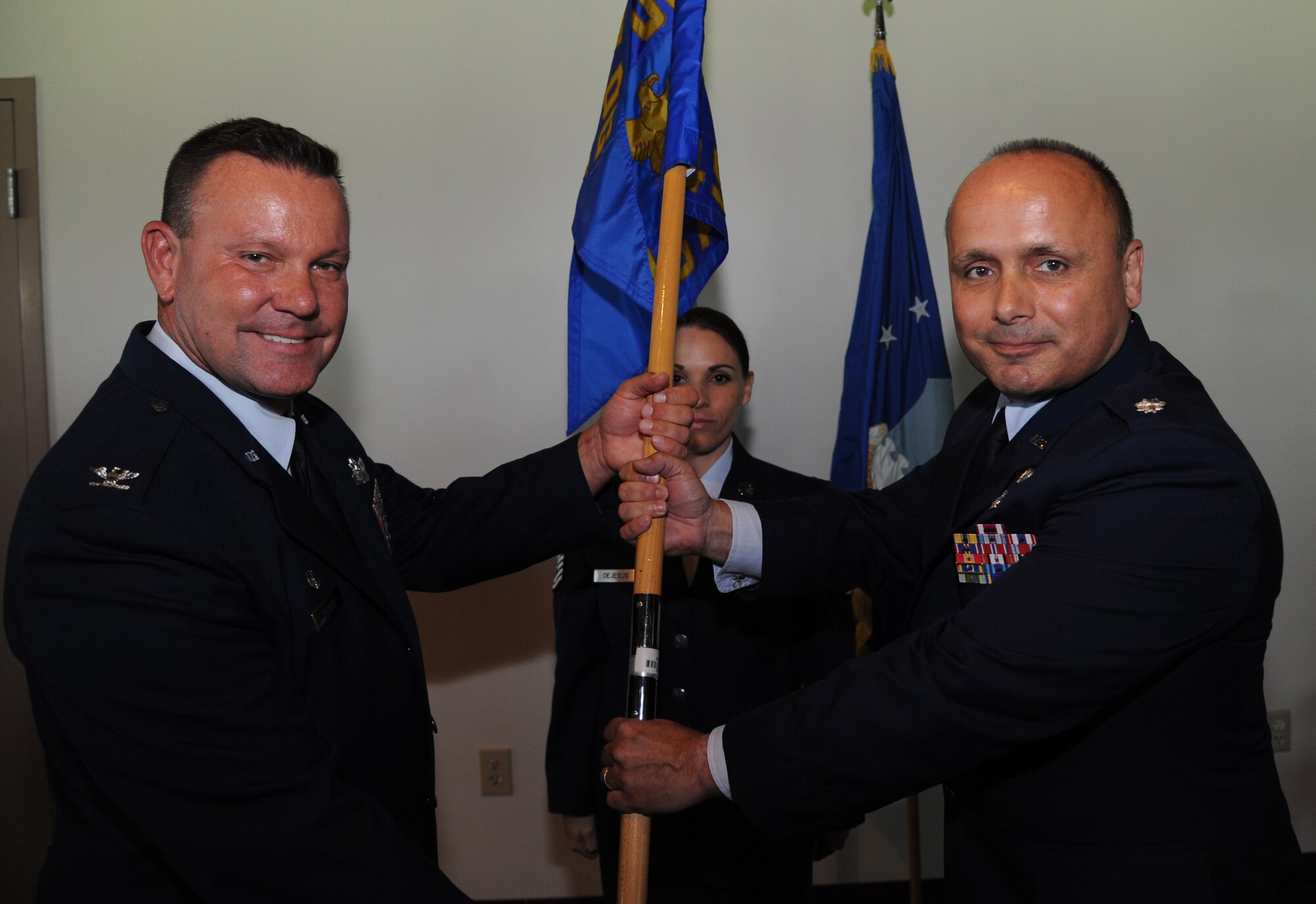 (Left) Col. William Rolocut, 927th Special Operations Group commander, passes the 45th Aeromedical Evacuation Squadron guidon to Lt. Col. James Palmisano during a change of command ceremony here June 6. Lt. Col. Deborah Grove relinquished command of the 45 AES to Palmisano. (U.S. Air Force photo by Senior Airman Xavier Lockley)
