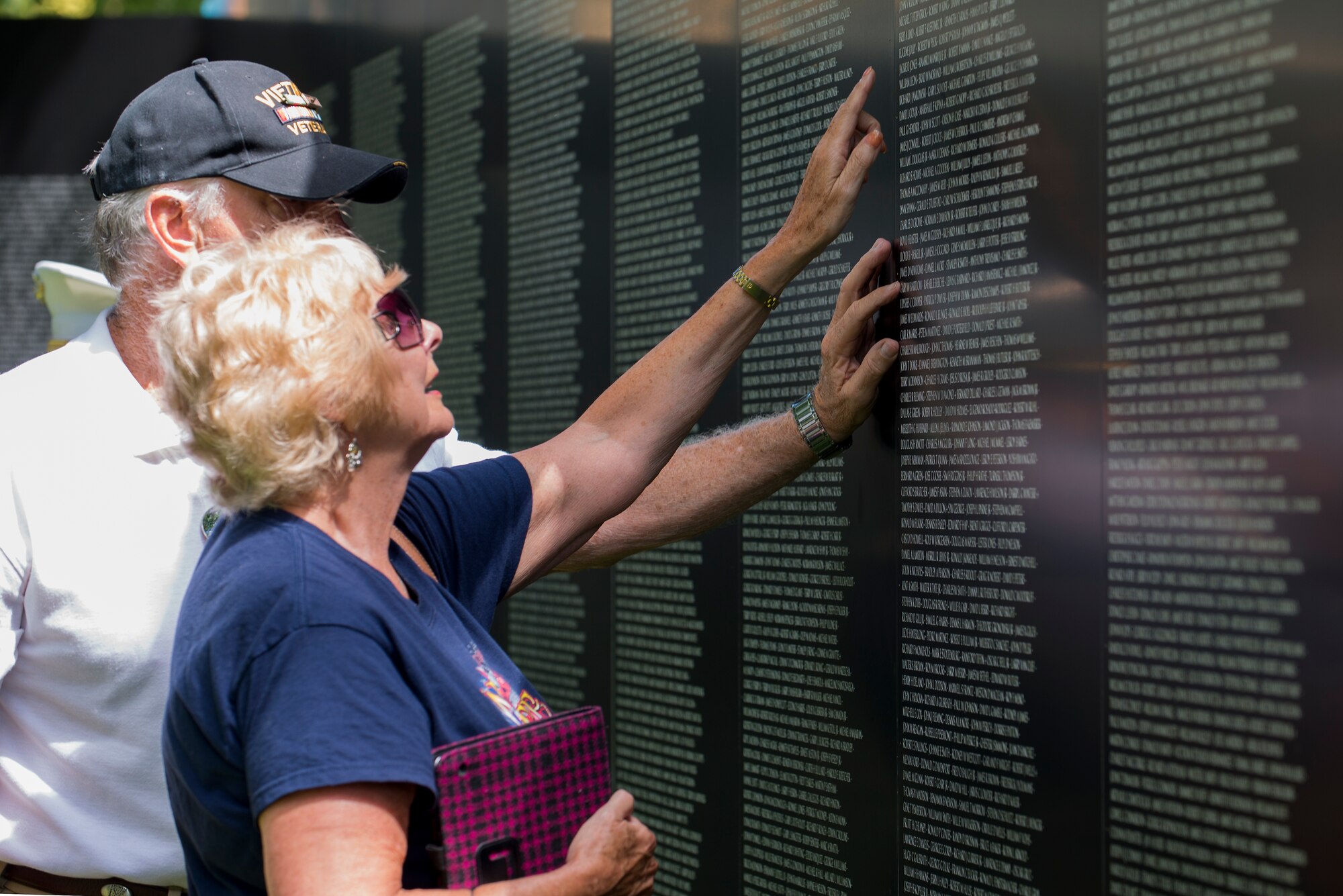 A couple found the name of a loved one they lost during the Vietnam War at the Eternal Flame Park, St. Louis, Missouri, June 5, 2015. The Traveling Vietnam Wall is a tribute dedicated to the memory of the servicemembers who lost their lives in the Vietnam War. (U.S. Air Force Photo by Airman 1st Class Megan Friedl)