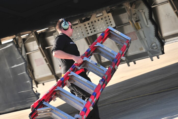A 509th Aircraft Maintenance Squadron crew chief cares a ladder to a B-2 Spirit to prep the aircraft for refueling at Royal Air Force Fairford, England, June 7, 2015. A hot-pit refueling was conducted after the B-2 Spirit landed on RAF Fairford, England, showcasing the capability of the aircraft to forward deploy and deliver conventional and nuclear deterrence anytime and anywhere. (U.S. Air Force photo/Senior Airman Malia Jenkins)
