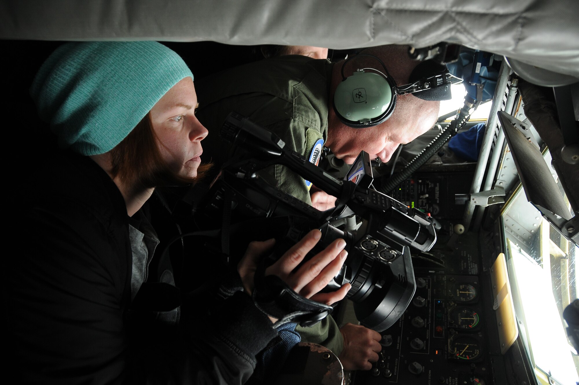 Photographer, Leah Schwartz from Sioux City, Iowa television station KTIV, photographs a mid-air refueling from the boom operator’s window alongside Chief Master Sgt. Al Mast in the back of an Air Force KC-135. Mast is the “Chief Boom” with the 185th Air Refueling Wing, Iowa Air National Guard based in Sioux City, Iowa. (U.S. Air National Guard photo by Master Sgt. Vincent De Groot/Released)