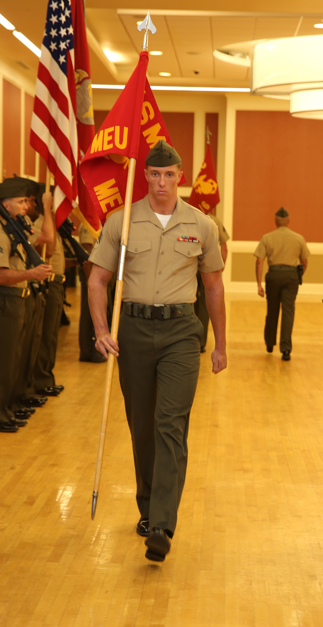 U.S. Marine Corps Sgt. Jarod Burnett, 22nd Marine Expeditionary Unit (MEU) intelligence analyst and native of Philadelphia, marches to his position during a change of command ceremony at Marine Corps Base Camp Lejeune, N.C., June 5, 2015. U.S. Marine Col. Todd Simmons assumed command of the 22nd MEU. (U.S. Marine Corps photo by Cpl. Caleb McDonald)