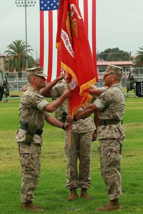 Lieutenant Col. Damon K. Burrows, left, the newly-appointed commanding officer of 9th Communication Battalion, I Marine Expeditionary Force Headquarters Group, receives the battalion colors from Lt. Col. Matthew R. Simmons, outgoing commanding officer, during a change of command ceremony aboard Marine Corps Base Camp Pendleton, Calif., June 4, 2015. Burrows most recently served as the assistant chief of staff, G-6, for the 1st Marine Logistics Group, I MEF, and said he plans to increase the battalion’s cyber operations presence and effectiveness. (U.S. Marine Corps photo by Lance Cpl. Caitlin Bevel)