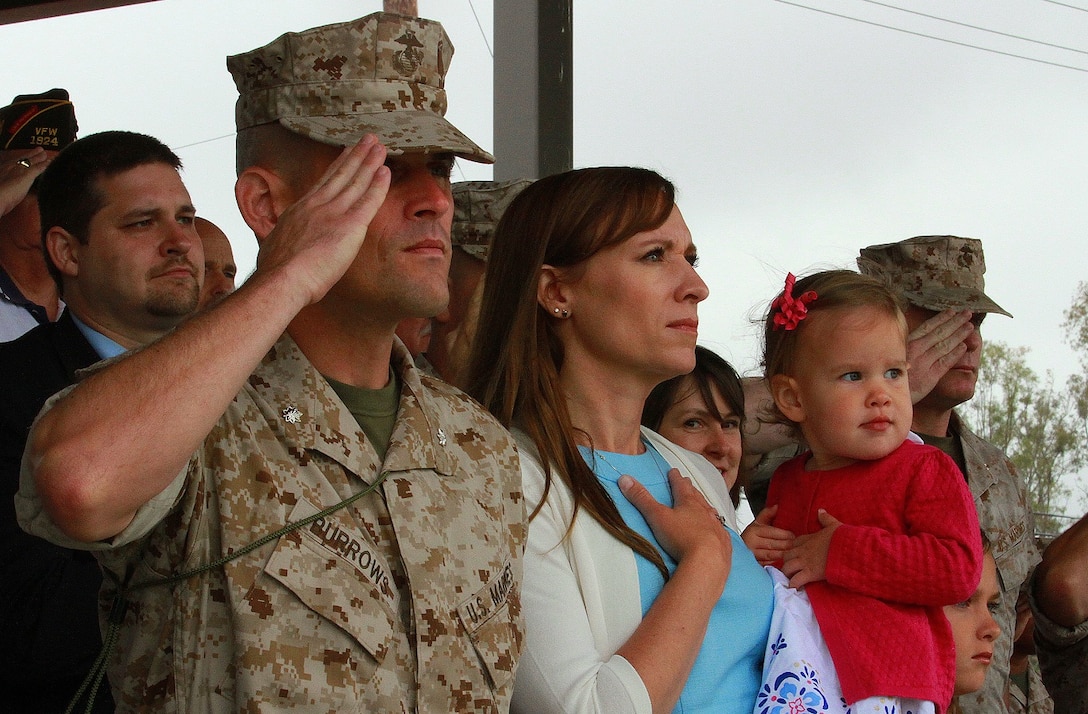 Lieutenant Col. Damon K. Burrows, the newly-appointed commanding officer of 9th Communication Battalion, I Marine Expeditionary Force Headquarters Group, and his family render honors to the national colors during a change of command ceremony aboard Marine Corps Base Camp Pendleton, Calif., June 4, 2015. Burrows most recently served as the assistant chief of staff, G-6, for the 1st Marine Logistics Group, I MEF, and said he plans to increase the battalion’s cyber operations presence and effectiveness. (U.S. Marine Corps photo by Lance Cpl. Caitlin Bevel)