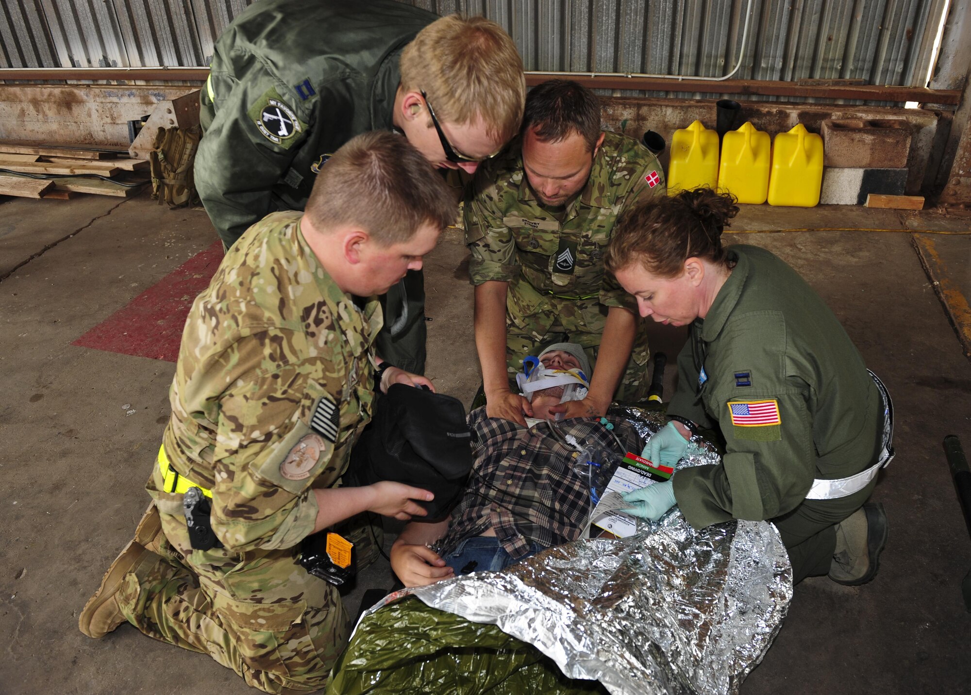 U.S. Air Force and Royal Danish air force medical personnel treat a simulated victim for neck and head injuries during an Angel Thunder 2015 mass casualty exercise at Winslow-Lindbergh Regional Airport, Ariz., June 5, 2015. Service members, University of Arizona and Northern Arizona University students acted as simulated patients to create a realistic experience during the exercise. (U.S. Air Force photo/Airman 1st Class Chris Drzazgowski)