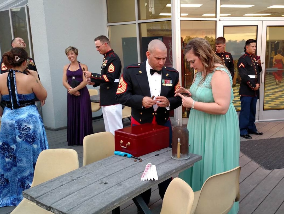 29 May 2015 – SgtMaj Robinson coaches Christine Sigler, a Human Resources Assistant with WTBN, on how to prepare a cigar during the Weapons Training Battalion Dining In on the observation deck to the USS North Carolina.
