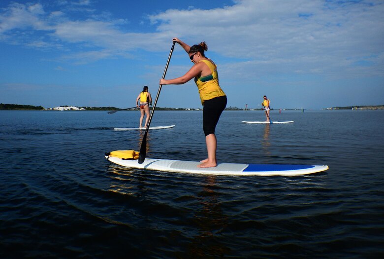 Sara Francis, Kirsten J. Nunweiler and Stephany Pippin, assigned to the 1st Special Operations Force Support Squadron, paddle in the Santa Rosa Sound during a stand up paddle boarding class at Hurlburt Field, Fla., June 4, 2015. The Outdoor Recreation SUP class is new to Hurlburt Field this year and classes are held Tuesdays and Thursdays from 7:30 a.m. to 8:30 a.m. weekly at the Sound Side. (U.S. Air Force photo/Airman Kai White)