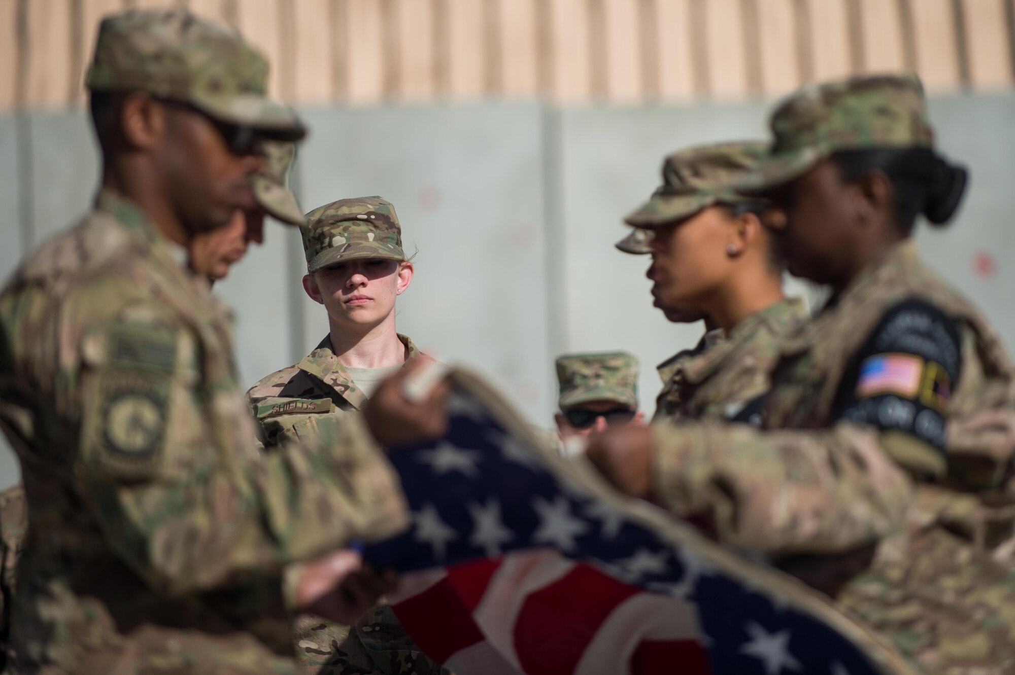 U.S. Air Force Senior Airman Chelsea Shields, Bagram Air Field honor guard member, helps fold a flag during a Memorial Day retreat ceremony at Bagram Air Field, Afghanistan, May 25, 2015. Memorial Day is dedicated to remembering U.S. men and women who gave their lives while in military service protecting and defending national interests. (U.S. Air Force photo by Tech. Sgt. Joseph Swafford/Released)