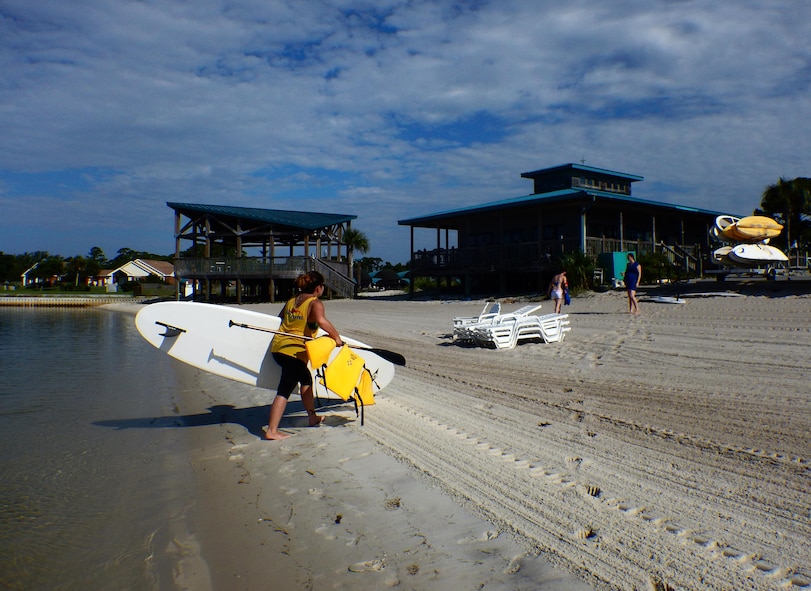 Kirsten J. Nunweiler, an Outdoor Recreation operations assistant, carries a stand up paddle board back to Outdoor Recreation after the second ever stand-up paddle boarding class on Hurlburt Field, Fla., June 4, 2015. The Outdoor Recreation SUP class is new to Hurlburt Field this year and classes are held Tuesdays and Thursdays from 7:30 a.m. to 8:30 a.m. weekly at the Sound Side.