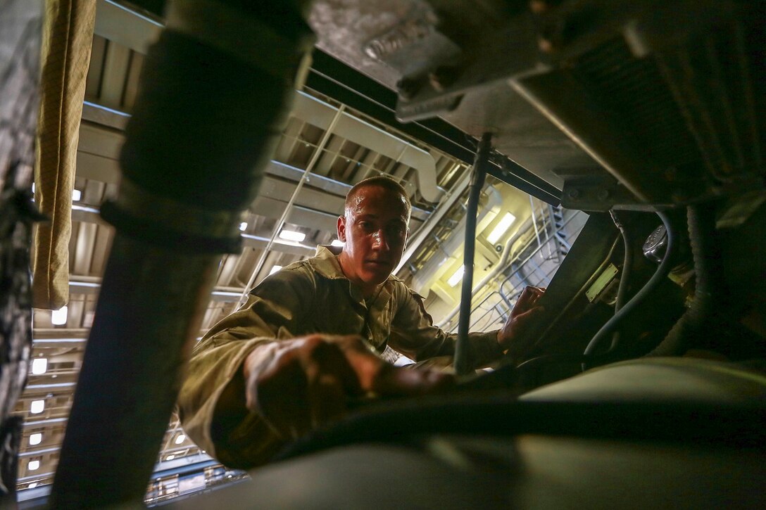 U.S. Marine Lance Cpl. Shane Ledbetter performs vehicle maintenance on a Light Armored Vehicle (LAV-25) aboard the USS Anchorage (LPD 23) in the Philippine Sea, June 5, 2015. Ledbetter is an LAV crewman with 1st Light Armored Reconnaissance Battalion, 15th Marine Expeditionary Unit. The Marines and Sailors of the 15th MEU constantly perform maintenance on their equipment to maintain combat readiness. (U.S. Marine Corps photo by Sgt. Jamean Berry/ Released)