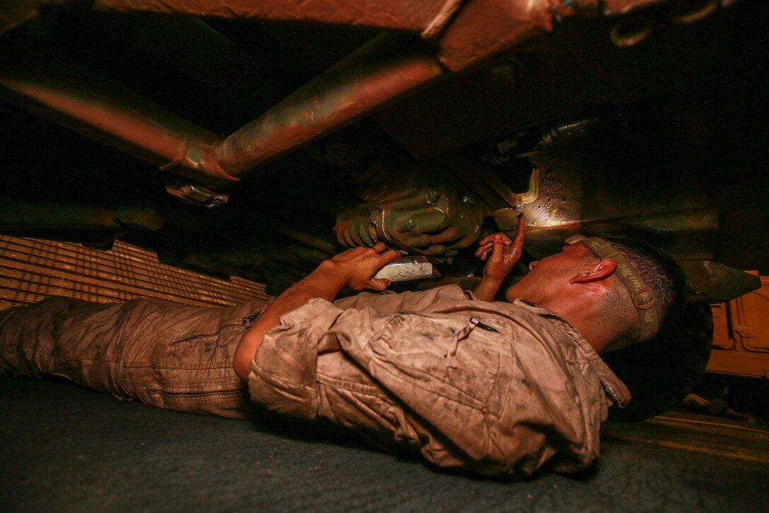 U.S. Marine Cpl. Bryan Delgado performs vehicle maintenance on a Light Armored Vehicle (LAV-25) aboard the USS Anchorage (LPD 23) in the Philippine Sea, June 5, 2015. Delgado is an LAV crewman with 1st Light Armored Reconnaissance Battalion, 15th Marine Expeditionary Unit.  The Marines and Sailors of the 15th MEU constantly perform maintenance on their equipment to maintain combat readiness. (U.S. Marine Corps photo by Sgt. Jamean Berry/Released)