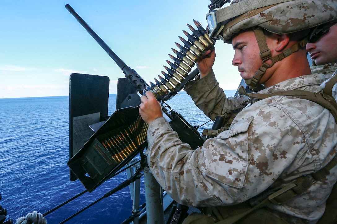 U.S. Marine Lance Cpl. George Camden loads an M2 .50-caliber machine gun aboard the USS Anchorage (LPD 23) in the Philippine Sea, June 5, 2015. Camden is a machine gunner with Battalion Landing Team 3rd Battalion, 1st Marine Regiment, 15th Marine Expeditionary Unit.  The Marines of BLT 3/1 man the mounted guns of the Anchorage to ensure its safety at sea. (U.S. Marine Corps photo by Sgt. Jamean Berry/ Released)
