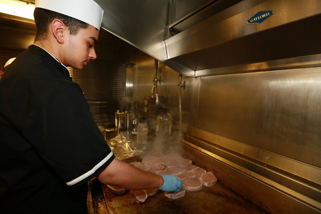 U.S. Navy Seaman Apprentice Nicholas Aragon cooks steak aboard the USS Anchorage (LPD 23) in the Philippine Sea, June 6, 2015. Aragon is a culinary specialist aboard the USS Anchorage. The culinary specialists of the Anchorage take pride in ensuring the morale of all members aboard is kept high with new and interesting meal choices. (U.S. Marine Corps photo by Sgt. Jamean Berry/Released)