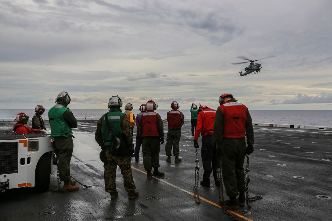 The Marines and Sailors with Marine Medium Tiltrotor Squadron 161 (Reinforced), 15th Marine Expeditionary Unit, and Essex Amphibious Ready Group prepare to chain down an AH-1Z Viper as it lands aboard the USS Anchorage (LPD 23) at sea in the Pacific Ocean, June 3, 2015. The Marines and Sailors of the 15th Marine Expeditionary Unit and Essex Amphibious Ready Group conduct flight operations to be better prepared for future operations. (U.S. Marine Corps photo by Sgt. Steve H. Lopez/Released)
