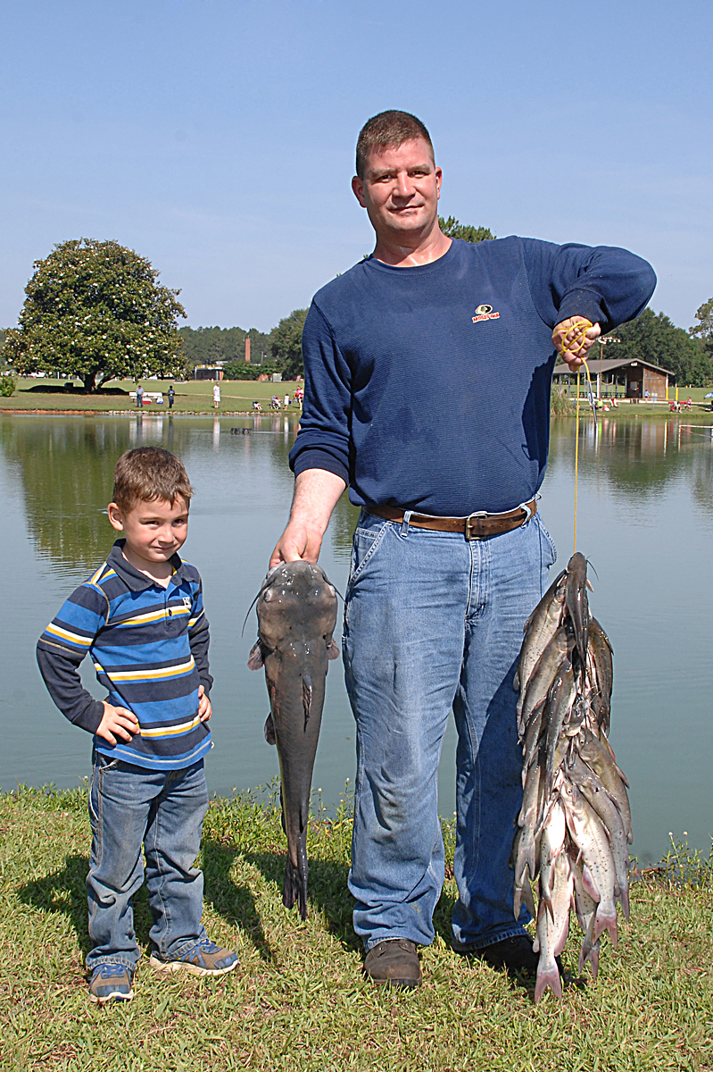 A young angler stands next to his 9.5-pound catfish he reeled in during Marine Corps Logistics Base Albany’s 27th annual Buddy Fishing Tournament at Covella Pond here, June 6. James Johnson, the boy’s father, only assisted his son by capturing the large catfish with a net.
