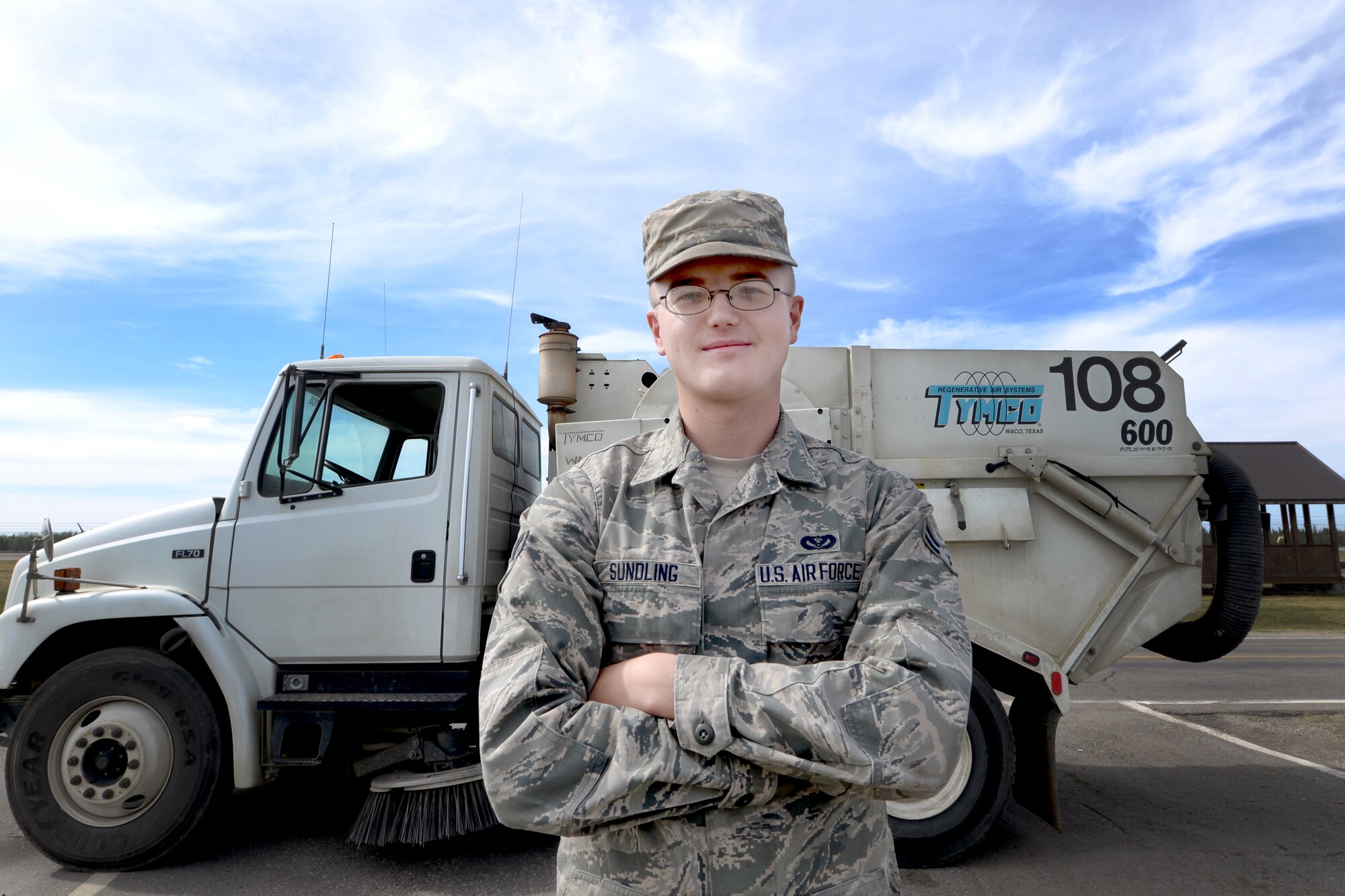 U.S. Air Force Airman First Class Andrew Sundling, a 354th Civil Engineer Squadron pavements and heavy equipment journeyman, stands in front of a street sweeper during his shift May 15, 2015, at Eielson Air Force Base, Alaska. Sundling spent a seven-month deployment in Al-Udeid and said he enjoys being a Dirt Boy. (U.S. Air Force photo by Senior Airman Ashley Nicole Taylor/Released)      