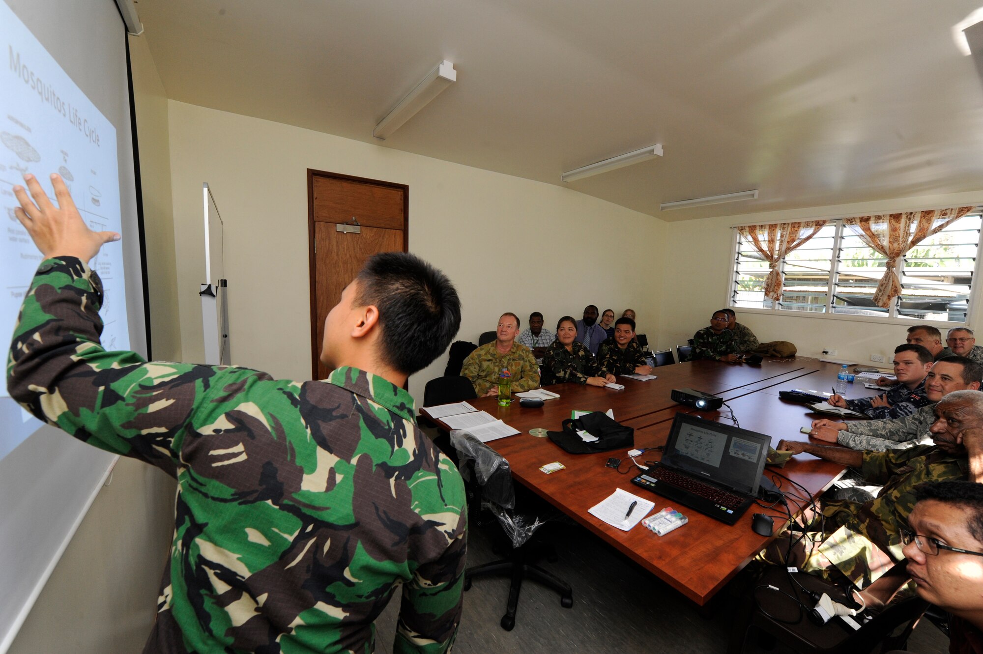 Indonesian Air Force 1st Lt. Daniel Suptra, 3rd Flight Squadron doctor, briefs military doctors from the U.S., Australia, Philippines, the Papua New Guinea Defence Force and researchers from the Papua New Guinea Institute of Medical Research on Dengue Fever in Indonesia and how best to prevent it during Pacific Angel 15-4 in Goroka, Papua New Guinea, June 4, 2015. The doctors and researchers shared their knowledge of diseases with each other and discussed how best to treat and prevent them from occurring. Efforts undertaken during Pacific Angel help multilateral militaries in the Pacific improve and build relationships across a wide spectrum of civic operations, which bolsters each nation???s capacity to respond and support future humanitarian assistance and disaster relief operations. (U.S. Air Force photo by Staff Sgt. Marcus Morris/Released)