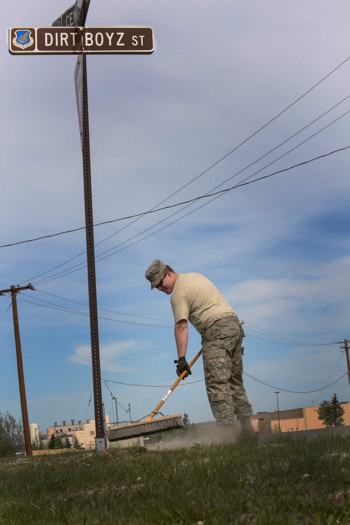 U.S. Air Force Airman First Class Adam Pryor, a 354th Civil Engineer Squadron pavements and heavy equipment journeyman, sweeps up rocks near the Dirt Boyz shop May 15, 2015, at Eielson Air Force Base, Alaska. After the long winter, Dirt Boyz clean up the base to avoid foreign object debris and help make it look nicer. (U.S. Air Force photo by Senior Airman Ashley Nicole Taylor/Released)