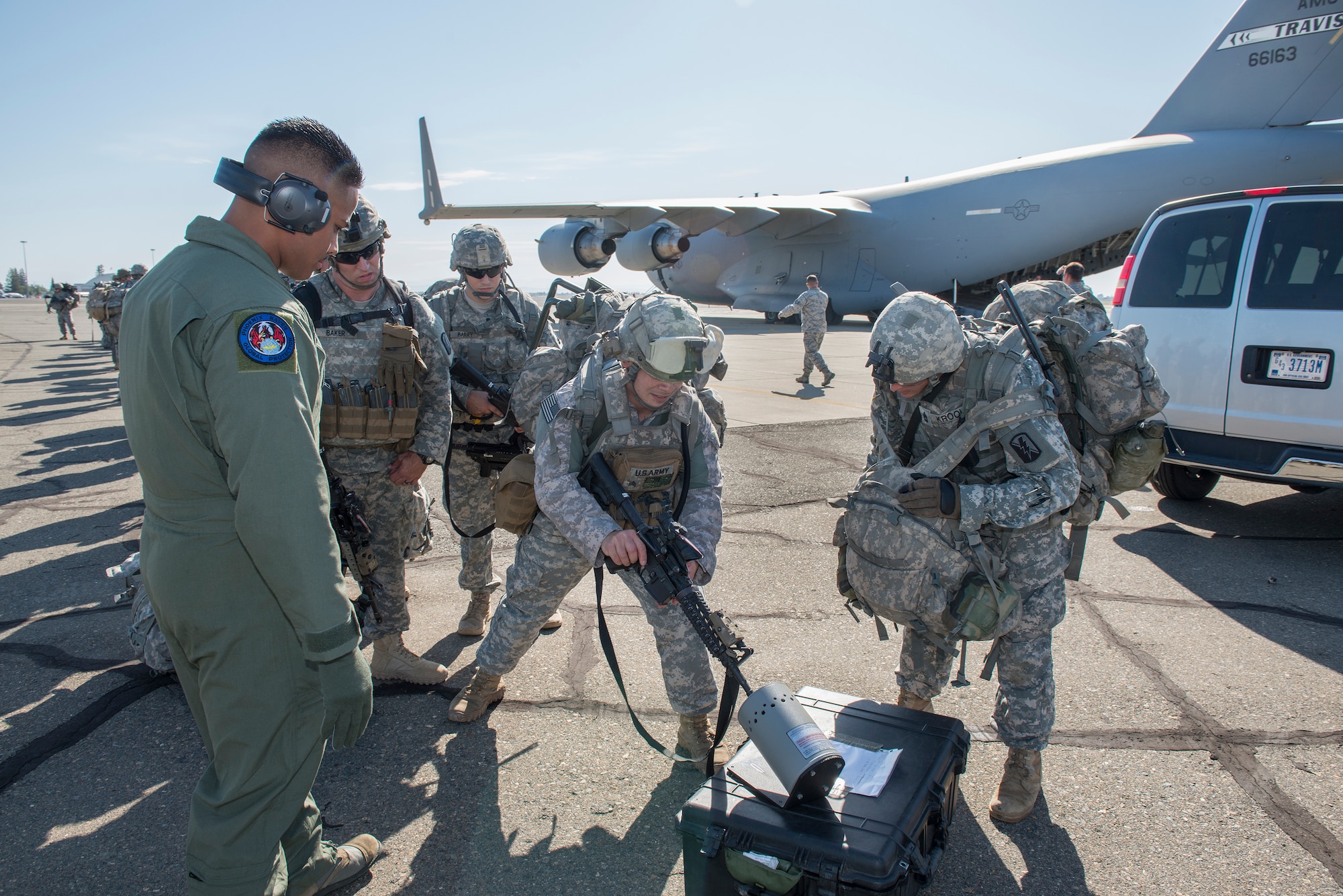 Army Nation Guard soldiers clear their weapons prior to boarding C-17 tail number 6063 bound for Fort Hunter Liggett in central California June 6, 2015. The mission was part of the 349th Air Mobility Wing's Air Force Specialty Code Training Weekend  providing reservists with hands-on, realistic training that helps to hone their skills. This AFSC Training Weekend centered around the wing's ability to respond to a major earthquake in northern California, while working in concert with other branches of the military, federal and state agencies to provide relief and support where needed. (U.S. Air Force Photograph by Heide Couch/Released)