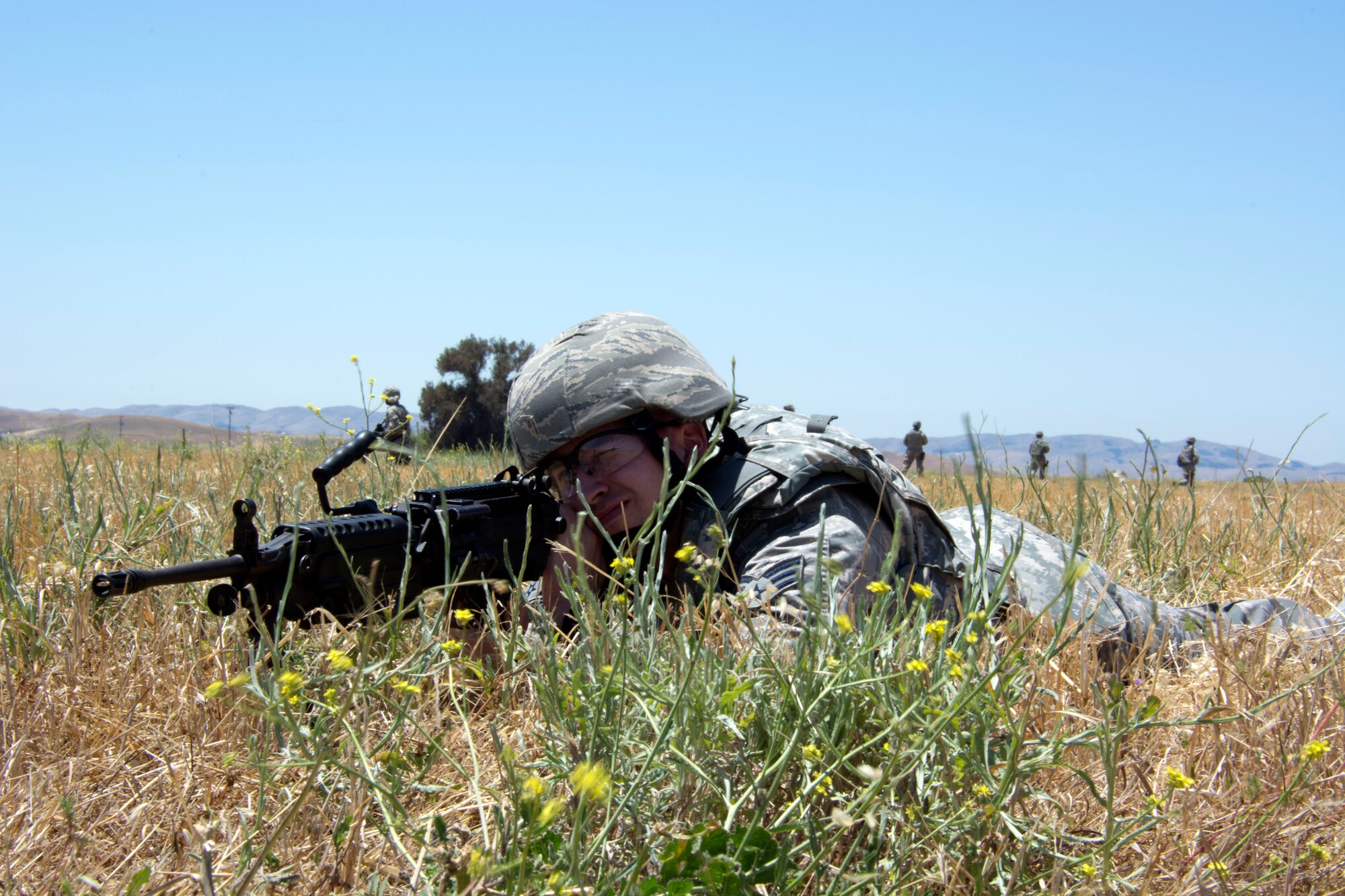 Senior Airman Jake Chanay, 349th Security Forces Squadron, sets up security with his M249 squad automatic weapon June 6, 2015 during a dismounted patrol at Travis Air Force Base, California. More than 40 defenders took part in a various expeditionary combat skills training scenarios during the Air Force Specialty Code weekend. (U.S. Air Force photo/Staff Sgt. Christopher Carranza)