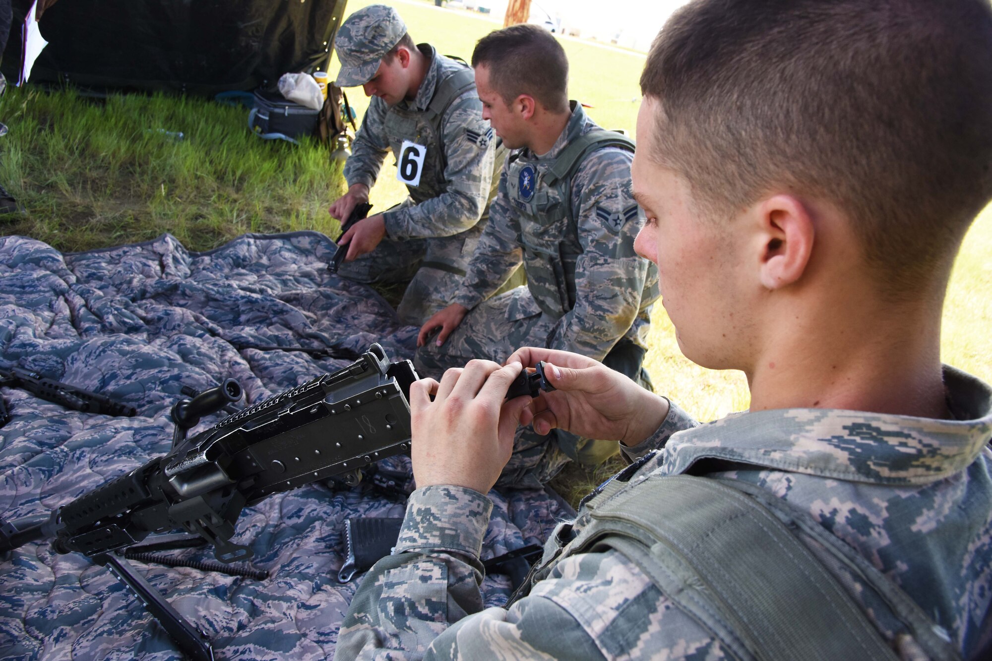 Team Malmstrom members assemble three weapons at the Box of Guns station during the 4th Annual Aces Cop Combat Challenge held at Malmstrom Air Force Base Mont., June 5. Each of the competitor’s 22 stations was designed to push Airmens’ physical and mental endurance throughout the course. (U.S. Air Force photo/Airman 1st Class Collin Schmidt)  