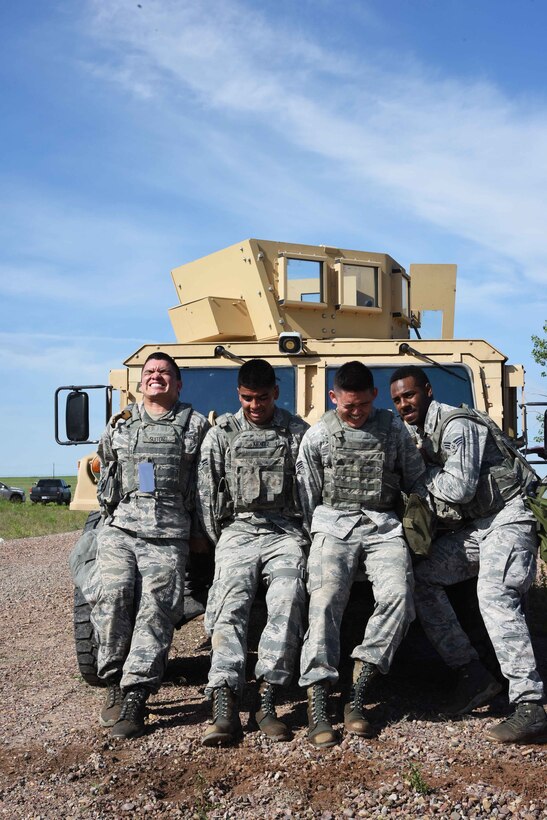 Four Team Malmstrom members push a Humvee uphill towards the finish line during the 4th Annual Aces Cop Combat Challenge at Malmstrom Air Force Base Mont., June 5. The Humvee weighed approximately 13,000 pounds. (U.S. Air Force photo/Airman 1st Class Collin Schmidt)