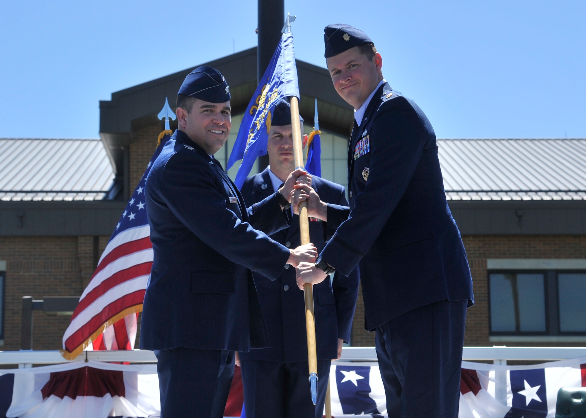 Col. Jonathan Duncan, the 336th Training Group commander, presents the 336th Training Support Squadron guidon to Maj. Timothy Dalby, the 336th TRSS commander, June 5, 2015, at Fairchild Air Force Base, Wash. Dalby took command of the 336th TRSS as the new squadron commander. The mission of the 336th TRSS is to provide superior resources and support services for Survival Evasion, Resistance and Escape training by way of four assigned flights and the squadron command staff. (U.S. Air Force photo/ Airman 1st Class Taylor Bourgeous)