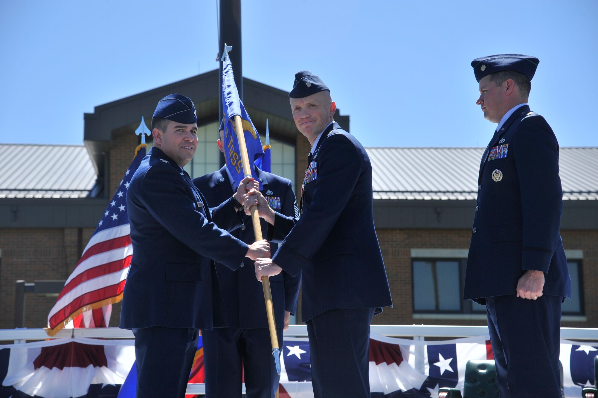 Lt. Col. Kelly Hannum, the former 336th Training Support Squadron commander, on right, passes the 336th TRSS guidon to Col. Jonathan Duncan, the 336th Training Group commander, June 5, 2015, at Fairchild Air Force Base, Wash. Hannum relinquished his position as the 336th TRSS commander in the change of command ceremony. The change of command is an official, formal and brief ceremony that is the military’s way of bestowing command responsibility of a unit to an officer.  (U.S. Air Force photo/ Airman 1st Class Taylor Bourgeous)