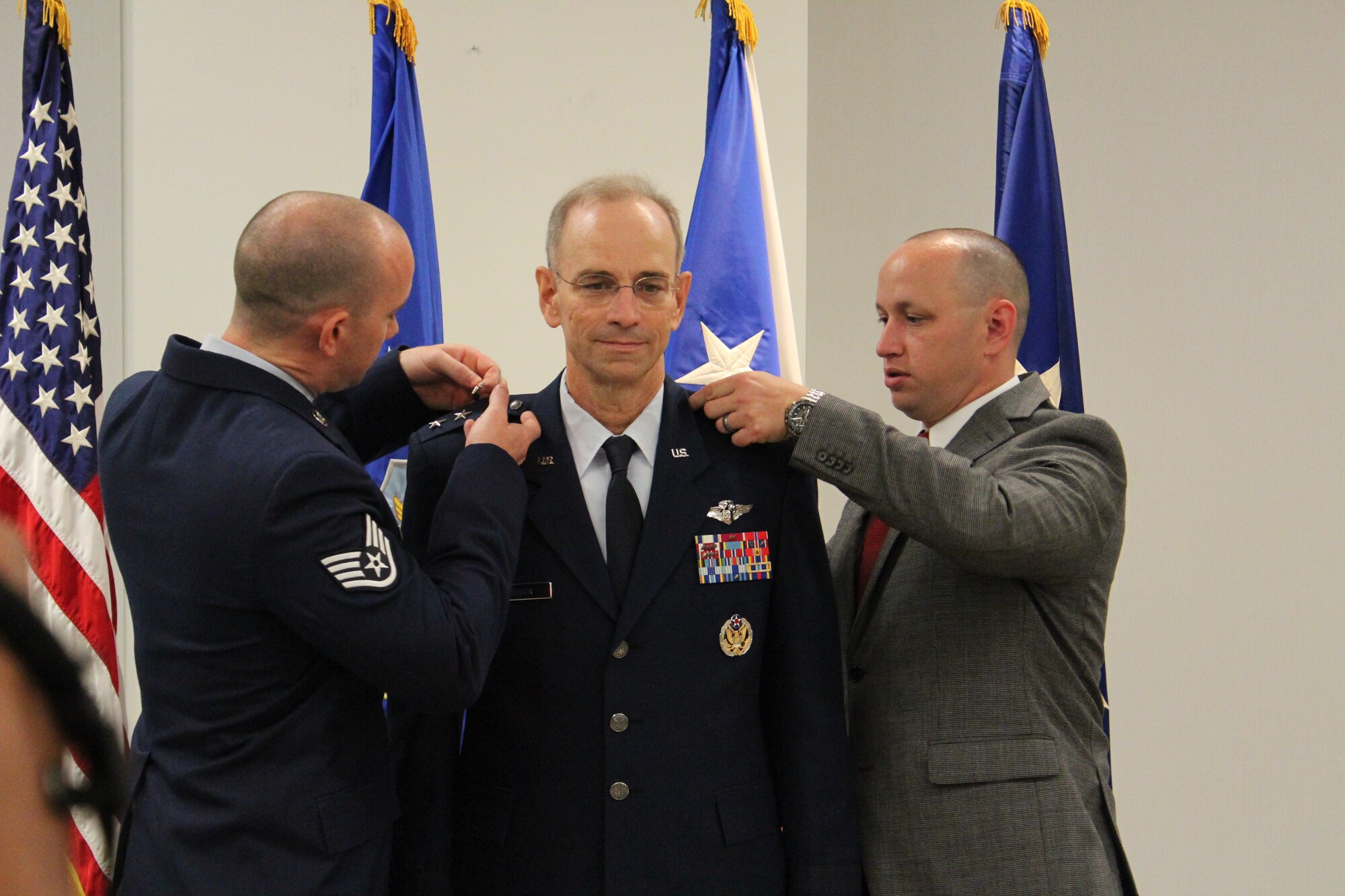 Staff Sergeant Ross Ediger, left, and Zachery Ediger, pin the third star on their father, Lt. Gen. Mark Ediger during the promotion ceremony June 8 at the Defense Health Headquarters, Falls Church, Va. General Ediger became the 22nd Air Force Surgeon General during the ceremony, officiated by Vice Chief of Staff Gen. Larry O. Spencer.  (U.S. Air Force photo by Jonathan Stock.)  