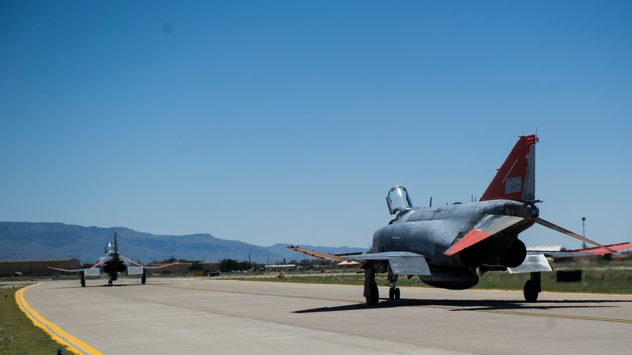 Two QF-4 Drones taxi onto the runway on June 3, 2015 at Holloman Air Force Base, N.M. Lieutenant. Col. Ronald King, 82nd Aerial Target Squadron, Detachment 1 commander, flew the QF-4 for the first time solo, making him the last pilot in the Air Force that learned to fly the QF-4. He was accompanied by James Harkins, a civilian pilot with the 82nd ATRS, Det 1, who also served as King’s instructor pilot at the U.S. Air Force Academy in the 1990s and at Luke Air Force Base, Ariz. in the early 2000s. (U.S. Air Force photo by Airman 1st Class Emily A. Kenney/Released)