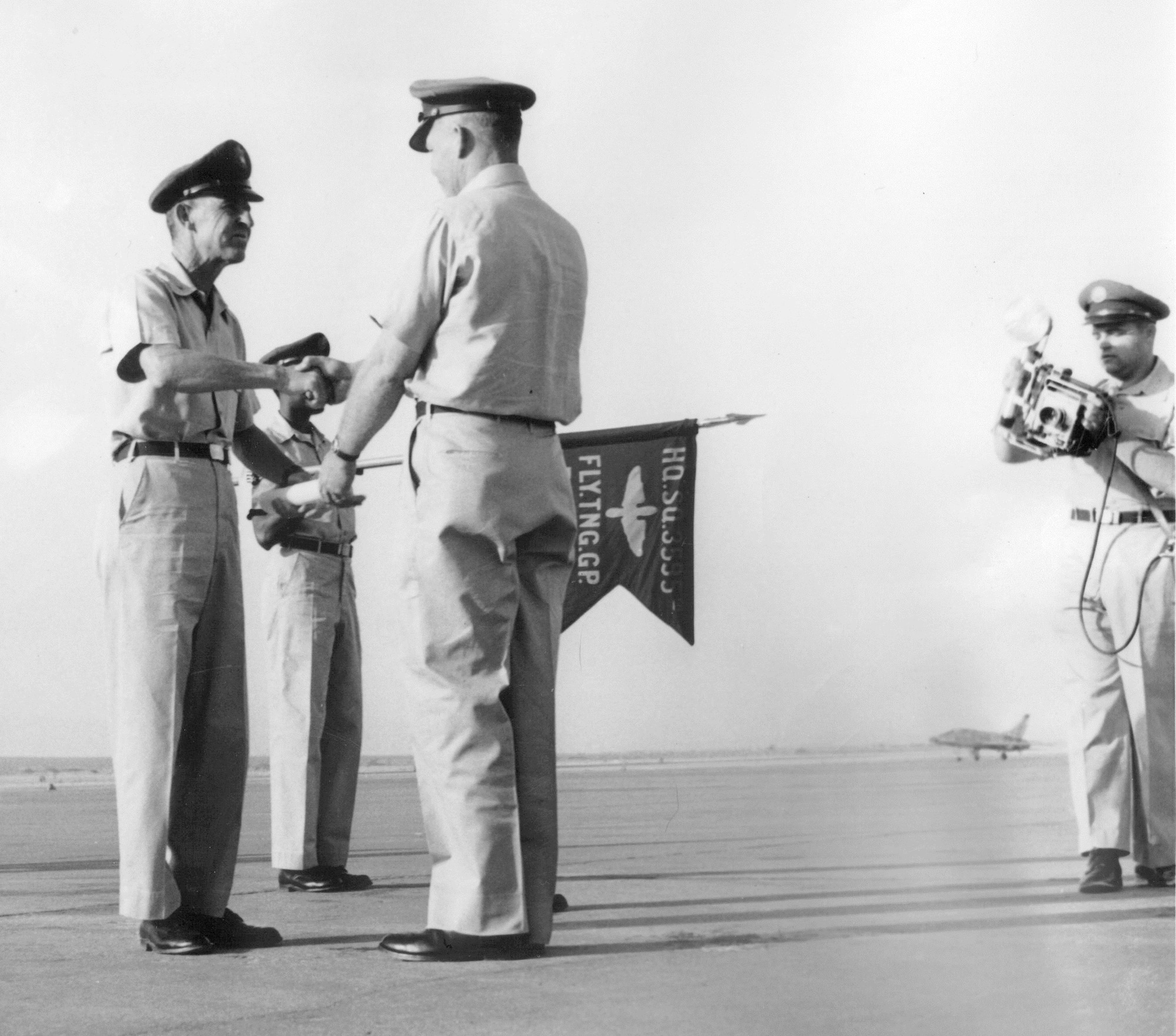 The guidon for the Headquarters Squadron, 3595th Flying Training Group can be seen during a ceremony on the flightline at Nellis Air Force Base, Nev., in 1956. Today's guidon traces its heritage back to smaller flags used by cavalry units in Europe during the late 1700s and early 1800s; these were used by squadrons within a larger regimental formation both on the battle field and in camps. (Courtesy photo) 