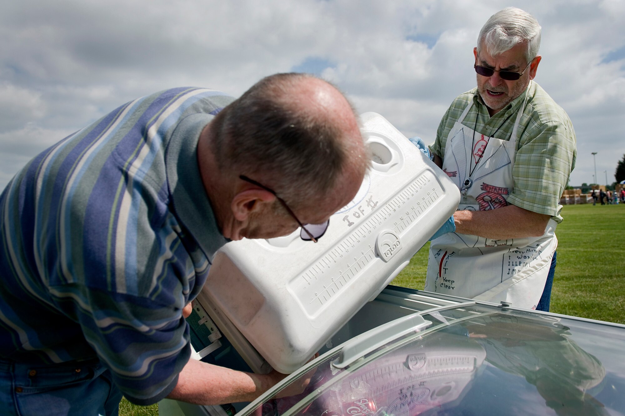Hal Job, 434th Air Refueling Wing honorary wing commander, right,  and Dr. Robert Beckett, Grissom Community Council member dump, ice into a cooler at the family day picnic at Grissom Air Reserve Base, Ind., June 6, 2015. Members and their families gathered for an afternoon of fun and festivities that provided an insight into what the unit does in support of the Air Force mission. (U.S. Air Force photo/Tech. Sgt. Douglas Hays)