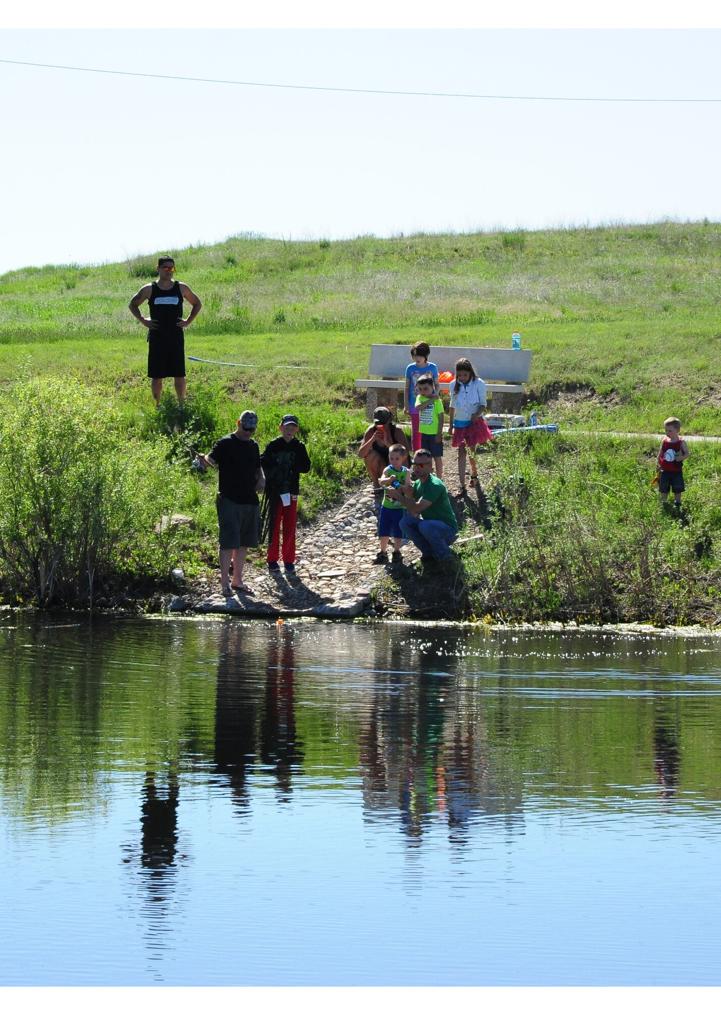 Team Malmstrom members participate in Kids Fishing Day, Jun. 6, 2015, at Pow Wow Park, Malmstrom Air Force Base, Mont.  The pond was stocked by the U.S. Fish and Wildlife Service with 12 inch and larger trout, as well as three to five pound rainbow trout. (U.S. Air Force photo/2nd Lt. Annabel Monroe)