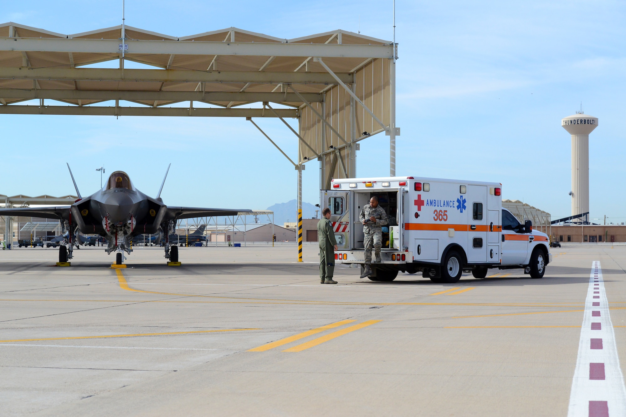 Capt. (Dr.) Matthew Lindsey, left, 56th Aerospace Medicine Squadron Flight Medicine flight surgeon, and Staff Sgt. Brian Lamar, 56th AMDS Flight Medicine technician, simulate a response to an in-flight emergency on the Luke Air Force Base flightline. The ambulance and crew responds to any situation that may have an impact on a pilot, such as a loss of cabin pressure. If the situation is nonemergent, the patient returns to the flight medicine facility for treatment. If it is emergent, a flight medicine doctor will accompany the pilot to the nearest medical facility. 
