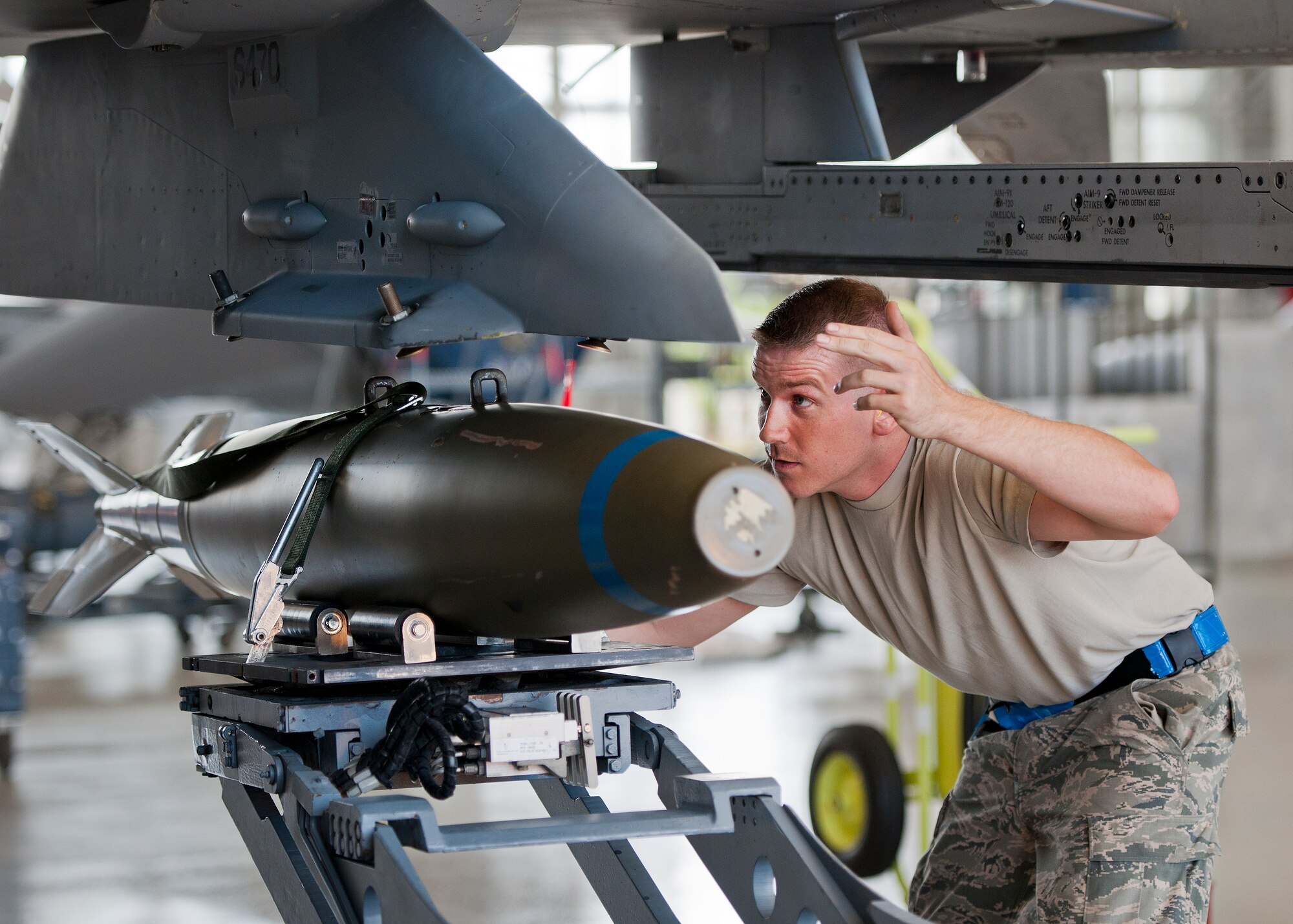Staff Sgt. Taleisan Colby, 96th Aircraft Maintenance Squadron Blue, guides a BDU-50 onto an F-16 Fighting Falcon during the second quarter load crew competition June 5 at Eglin Air Force Base, Fla.  The blue team lost the competition to the Red A-10 Thunderbolt II team that consisted of loading the missile and two BDU-50s.  (U.S. Air Force photo/Samuel King Jr.)