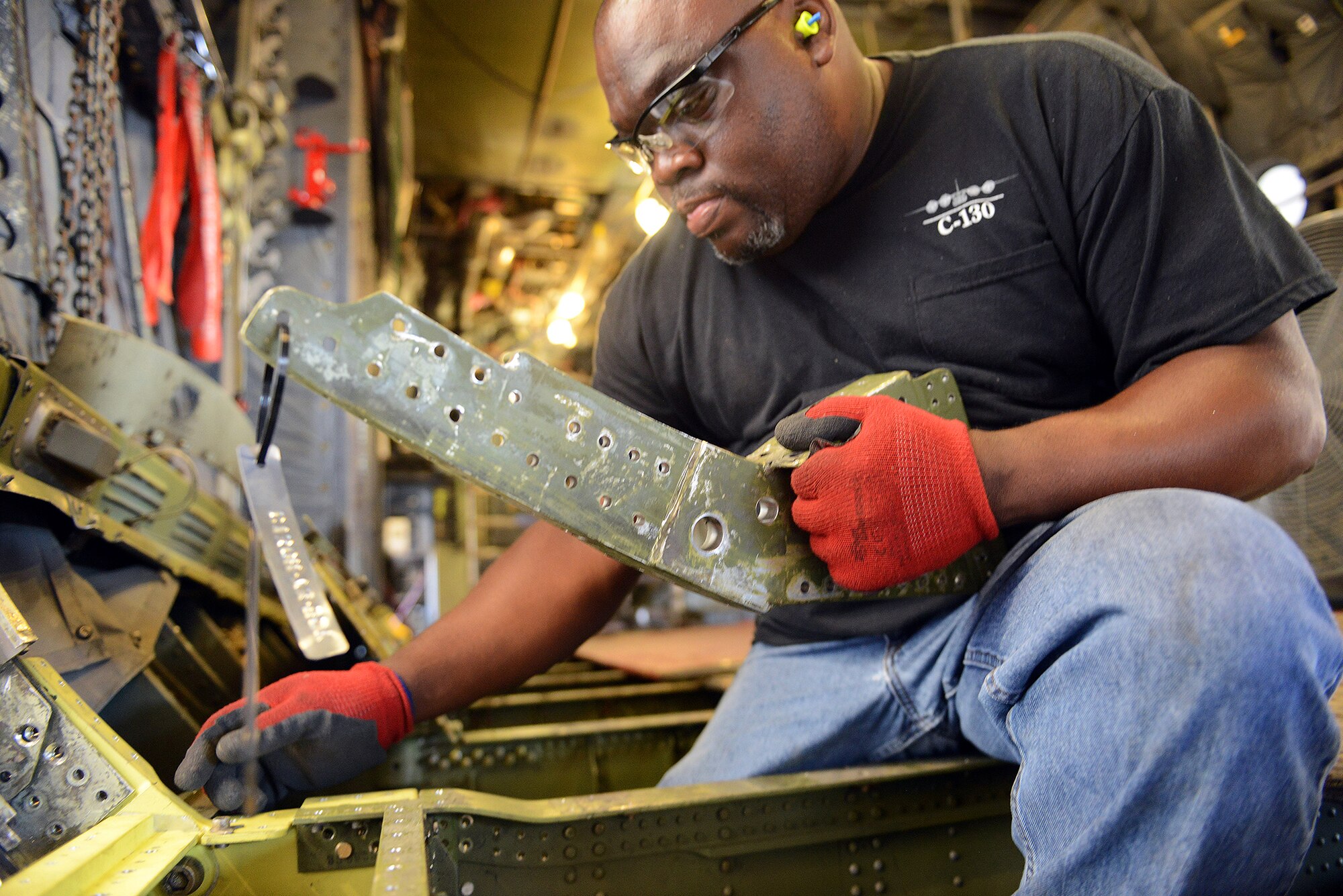 Albert Brown, 560th Aircraft Maintenance Squadron sheet metal mechanic, repairs a C-130 paratroop door as part of programmed depot maintenance at Robins. The PDM process includes overhaul, repair and modification of the aircraft. (U.S. Air Force photo by Tommie Horton)