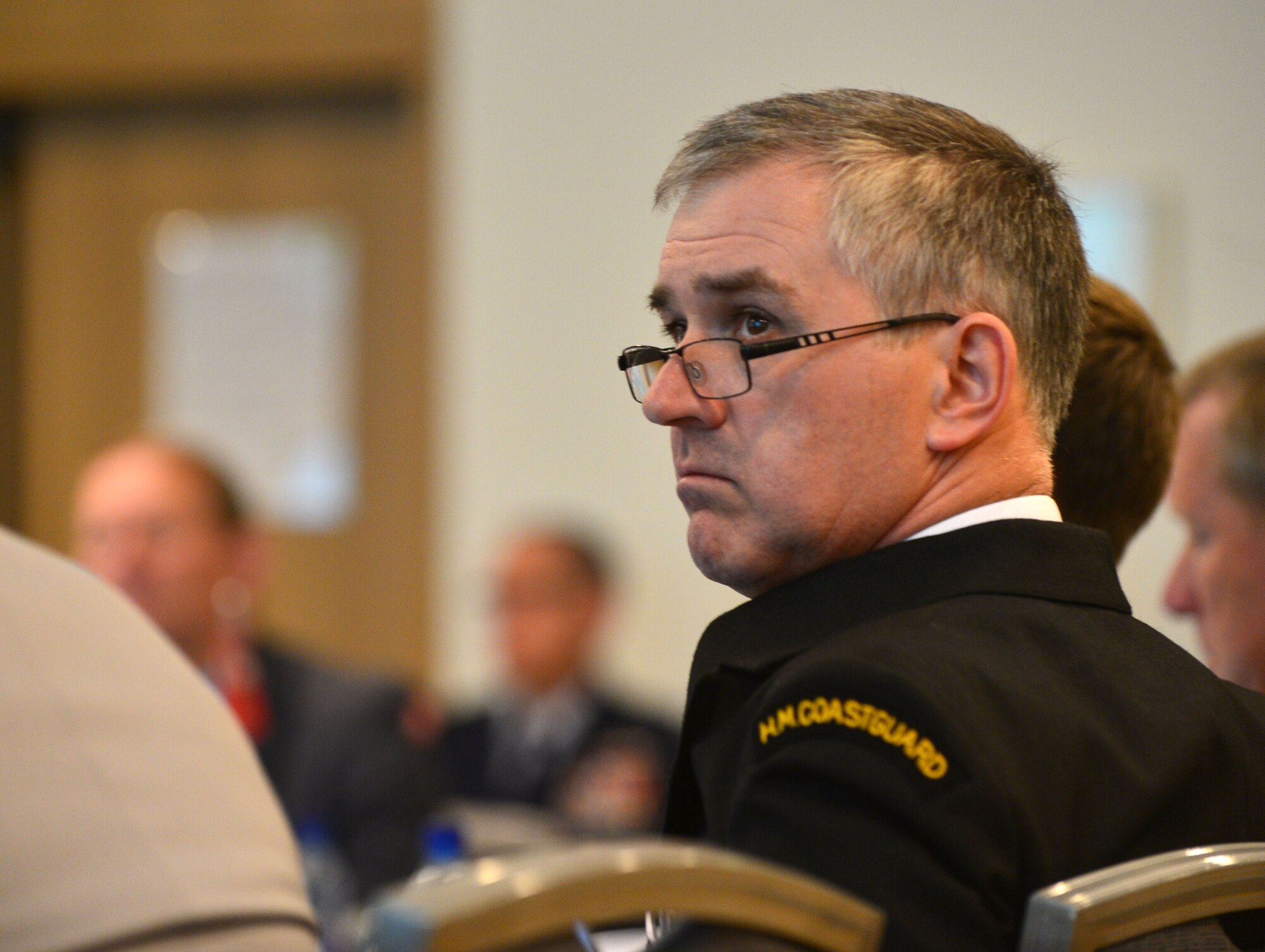 Roly McKie, Her Majesty's Coast Guard, listens to a presentation during the Arctic Security Forces Roundtable, May 12, 2015 in Reykjavik, Iceland. Representatives from 11 nations across Europe and North America met for the ASFR in order to promote regional understanding and enhance multilateral security operations within the Arctic area. The United Kingdom was one of four observer nations present at the conference. (U.S. Air Force photo by 2nd Lt. Meredith Mulvihill/Released)