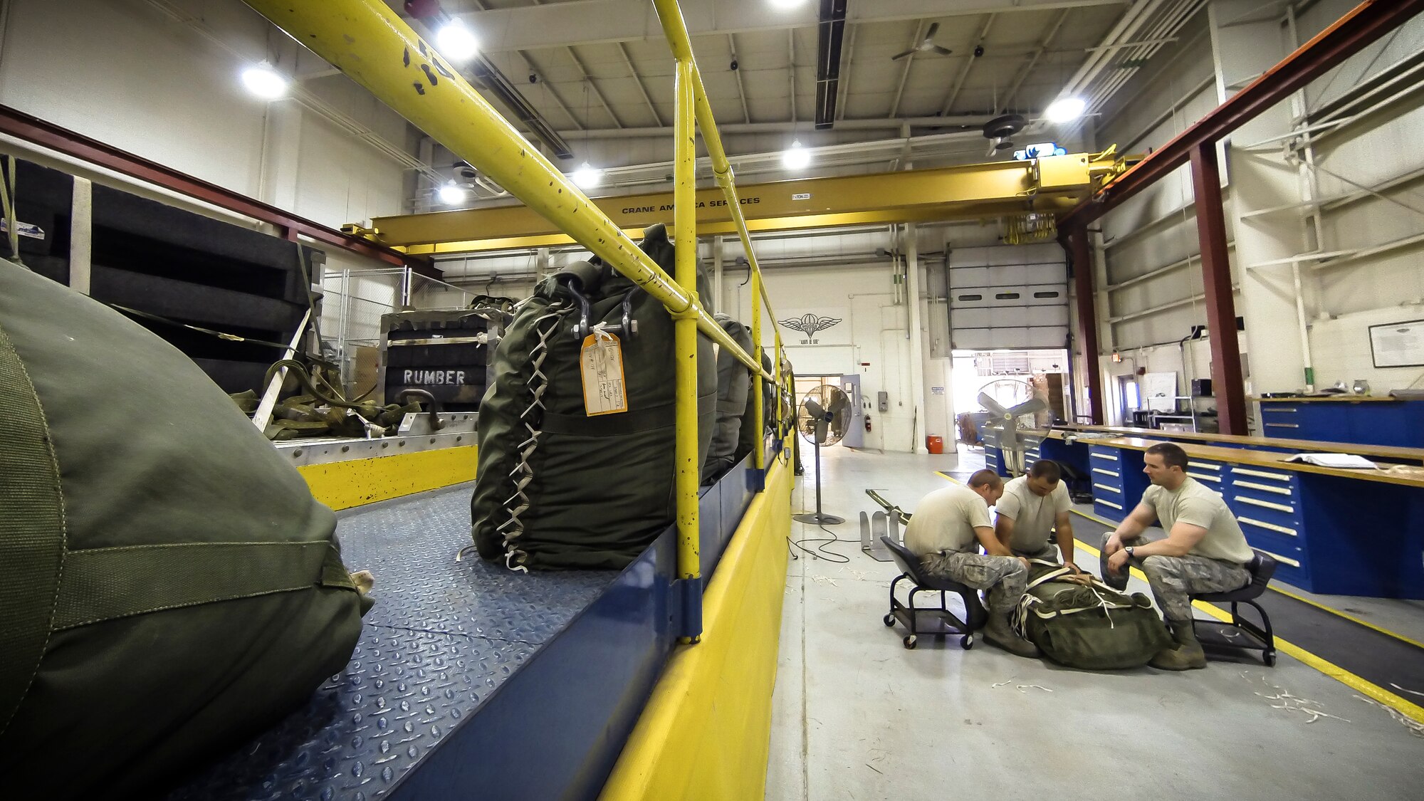 Technical Sgt. Jesse Sorrell (left), Technical Sgt. Jeremy Martinson and Technical Sgt. Joshua Ellis ties up a G-12E Type V platform parachute after recovering it from the dropzone on June 6, 2015. The Airman from the 182d Airlift Wing, Small Air Terminal, Peoria, Ill. check and repack the parachute after it was used in a recent C-130 air drop training mission with heavy equipment at the dropzone. (U.S. Air National Guard photo by Master Sgt. Scott Thompson/Released)