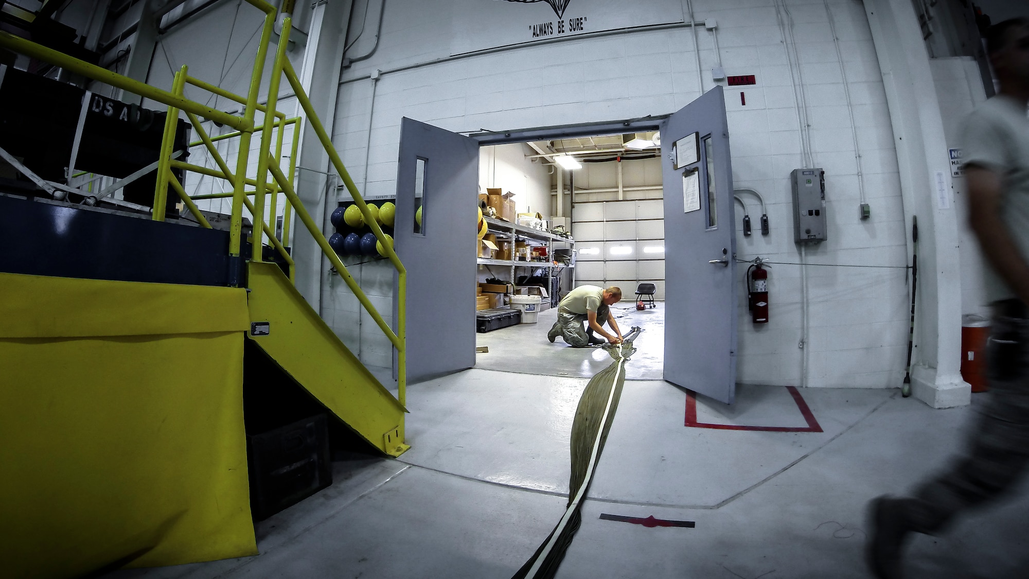 Technical Sgt. Jesse Sorrell ties up parachute cord on a G-12E Type V platform parachute after recovering it from the dropzone on June 6, 2015. The Airman from the 182d Airlift Wing, Small Air Terminal, Peoria, Ill. check and repack the parachute after it was used in a recent C-130 air drop training mission with heavy equipment at the dropzone. (U.S. Air National Guard photo by Master Sgt. Scott Thompson/Released)