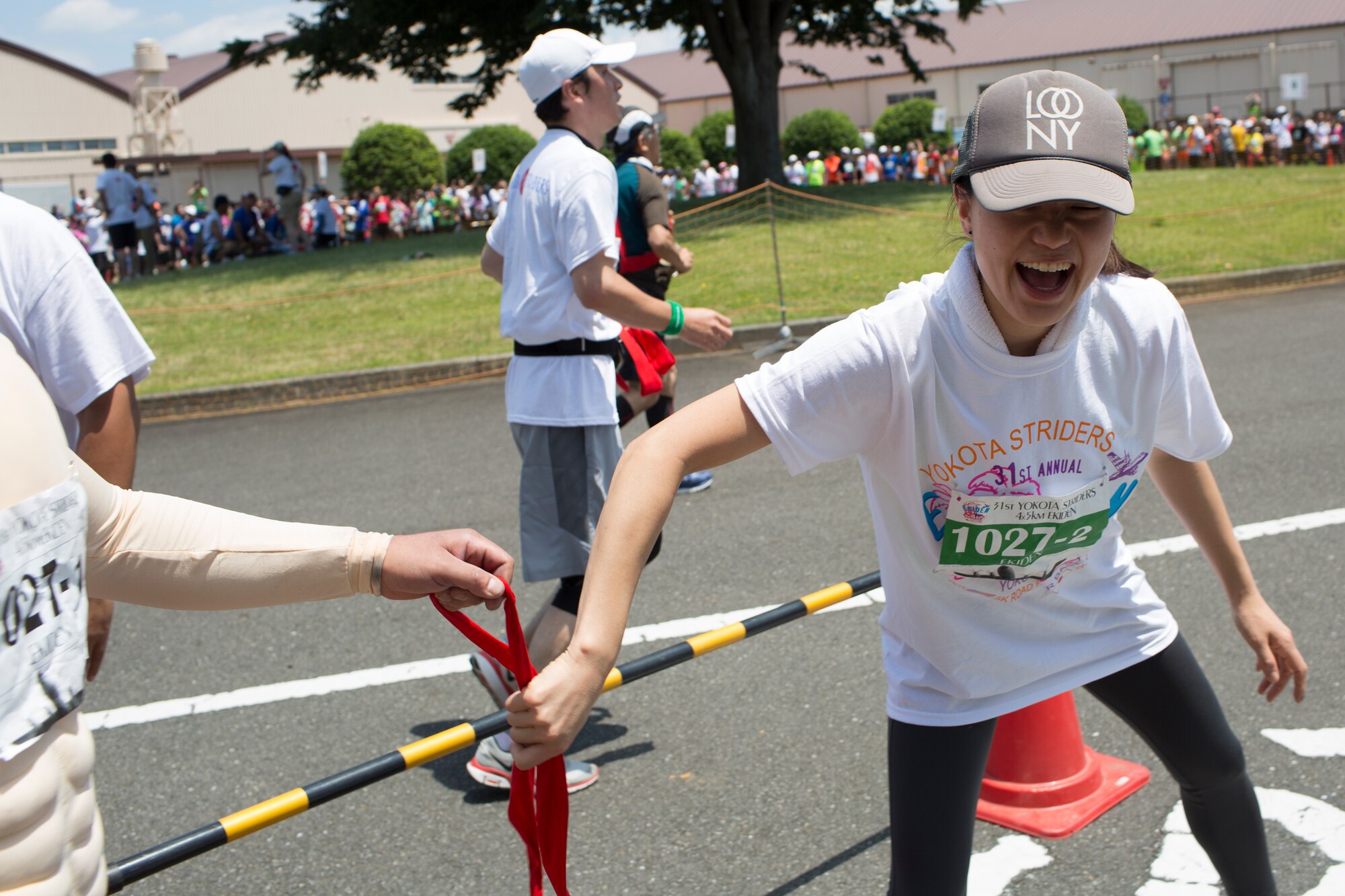 An Ekiden runner hands off a tasuki, a cloth sash, to the next runner during the 31st Annual Ekiden race at Yokota Air Base, Japan. More than 5,800 runners participated in the event sponsored by the Yokota Striders Running Club. (U.S. Air Force photo by Osakabe Yasuo/Released) 