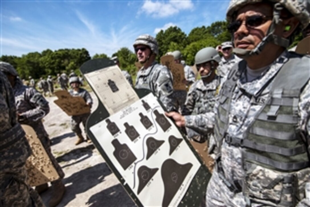 Army Reserve soldiers bring their qualification targets back for scoring after shooting M16A2 rifles at the Joliet Training Center in Elwood, Ill., June 6, 2015.  
