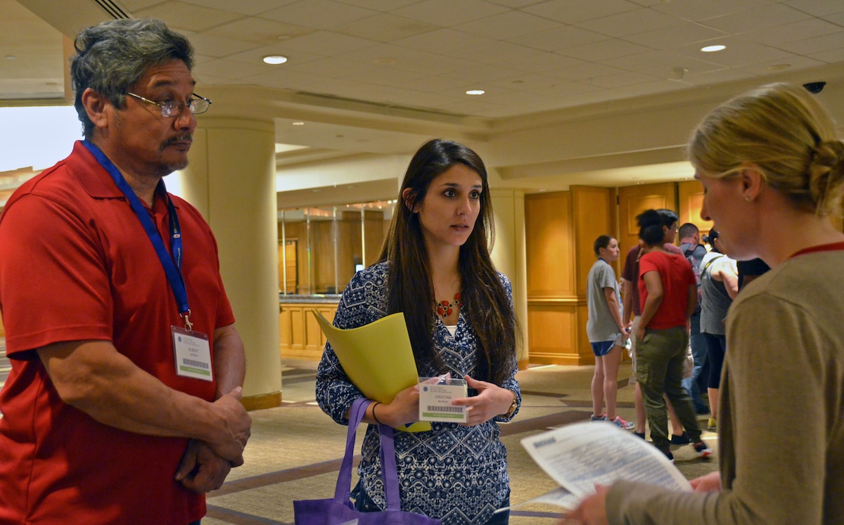 Maj. Laura Haver of the Air Force Reserve Yellow Ribbon Reintegration Program talks with Staff Sgt. Cristina Moreno and her father, retired Soldier Albert Moreno, during registration at a training weekend May 29, 2015, in Washington, D.C. The sergeant is a vehicle maintenance specialist with the 507th Logistics Readiness Squadron, Tinker Air Force Base, Okla., and recently returned froman overseas deployment. (U.S. Air Force photo by Senior Airman Monica Ricci)