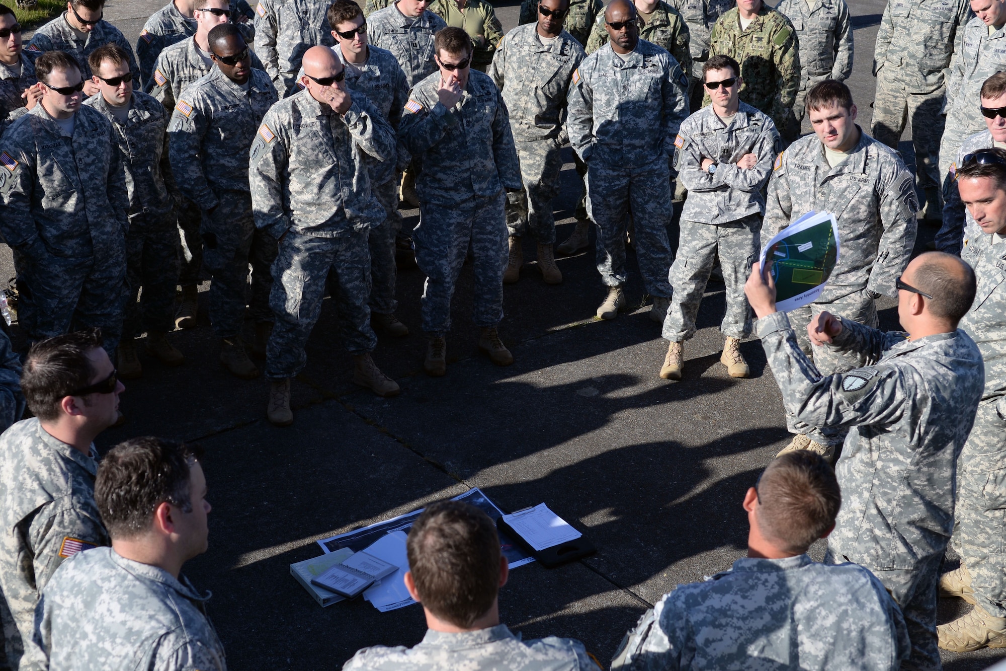 U.S. Special Operations Command -- Europe operators gather for a mission brief prior to donning their parachutes and loading an MC-130J Commando II assigned to the 67th Special Operations Squadron at RAF Mildenhall, England, to perform military free fall to their objective, the historic La Fiere drop zone near Sainte Mere Eglise, Normandy, France, June 7, 2015, to commemorate the 71st anniversary of D-Day. More than 60 SOCEUR operators performed the MFF jumps which were a small portion of the commemorative events which took place in strategic World War II sites throughout Normandy. (U.S. Air Force photo by Tech. Sgt. Stacia Zachary)