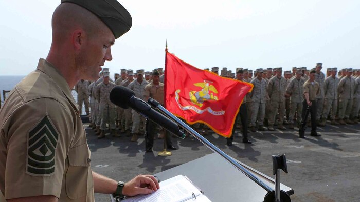 First Sgt. John Beckett, the company first sergeant for Kilo Company, Battalion Landing Team 3rd Battalion, 6th Marine Regiment, 24th Marine Expeditionary Unit, gives a speech during a ceremony commemorating the anniversary of the Battle of Midway aboard the dock landing ship USS Fort McHenry (LSD 43) in the Gulf of Aden, June 6, 2015. The 24th MEU is embarked on the ships of the Iwo Jima Amphibious Ready Group and deployed to maintain regional security in the U.S. 5th Fleet area of operations. 