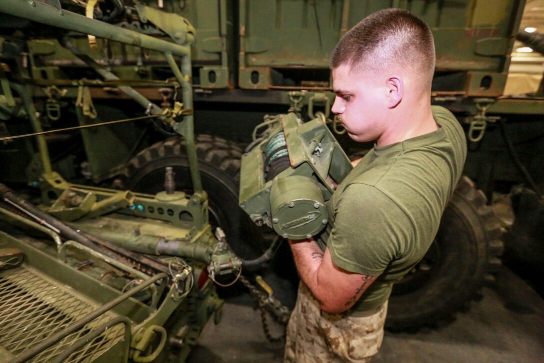 U.S. Marine Cpl. Donald Tippie places a winch on the back of an Internally Transportable-Light Strike Vehicle aboard the USS Anchorage (LPD 23) in the Philippine Sea, June 3, 2015. Tippie is a motor transportation quality control chief with the Command Element, 15th Marine Expeditionary Unit. The Marines of the 15th MEU constantly perform maintenance on their equipment to maintain combat readiness. (U.S. Marine Corps photo by Sgt. Steve H. Lopez/Released)