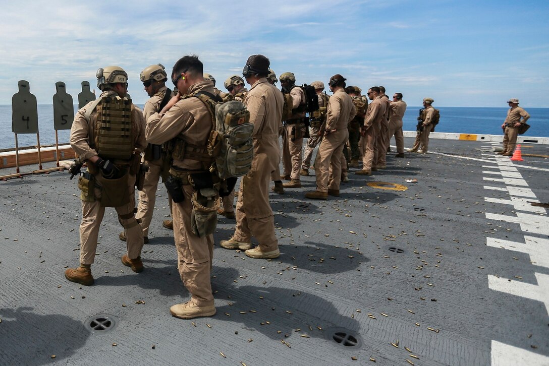 U.S. Marines with the 15th Marine Expeditionary Unit’s Maritime Raid Force prepare to fire their weapons on the flight deck of the USS Anchorage (LPD 23) in the South China Sea, June 7, 2015. The 15th MEU’s MRF must maintain their marksmanship proficiency while at sea on deployment. (U.S. Marine Corps photo by Sgt. Steve H. Lopez/Released)