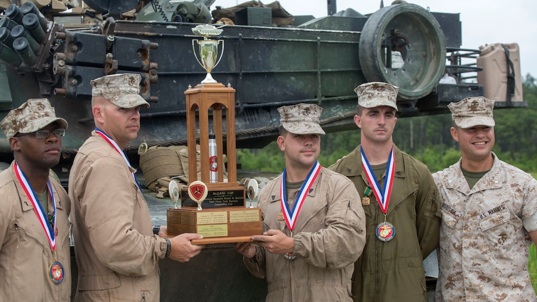 Lieutenant Col. Robert J. Bodisch, right, commanding officer of 2nd Tank Battalion, poses for a photo with the winning gunnery crew from 2nd Tank Battalion during the 13th annual TIGERCOMP at Marine Corps Base Camp Lejeune, N.C., June 5, 2015. The best tank gunner crews from 1st Tank Battalion, 2nd Tank Battalion and 4th Tank Battalion competed for top honors and the McCard trophy bringing the entire tank community, including tank battalion veterans, together for an entertaining display of the tanks force and powerful capabilities.