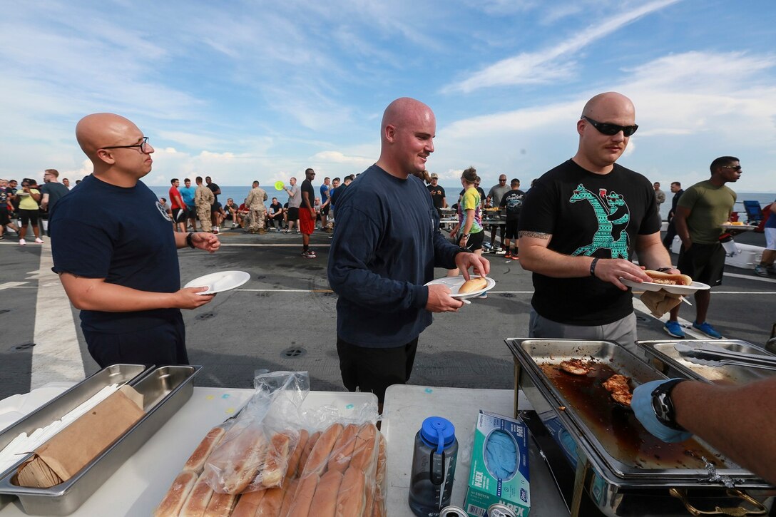 The Marines and Sailors of the 15th Marine Expeditionary Unit and USS Anchorage (LPD 23) fill their plates with food at a steel beach picnic aboard the USS Anchorage in the Philippine Sea, June 4, 2015. The Marines and Sailors of the 15th MEU and Essex Amphibious Ready Group hold such events to boost morale and build camaraderie. (U.S. Marine Corps photo by Sgt. Steve H. Lopez/Released)