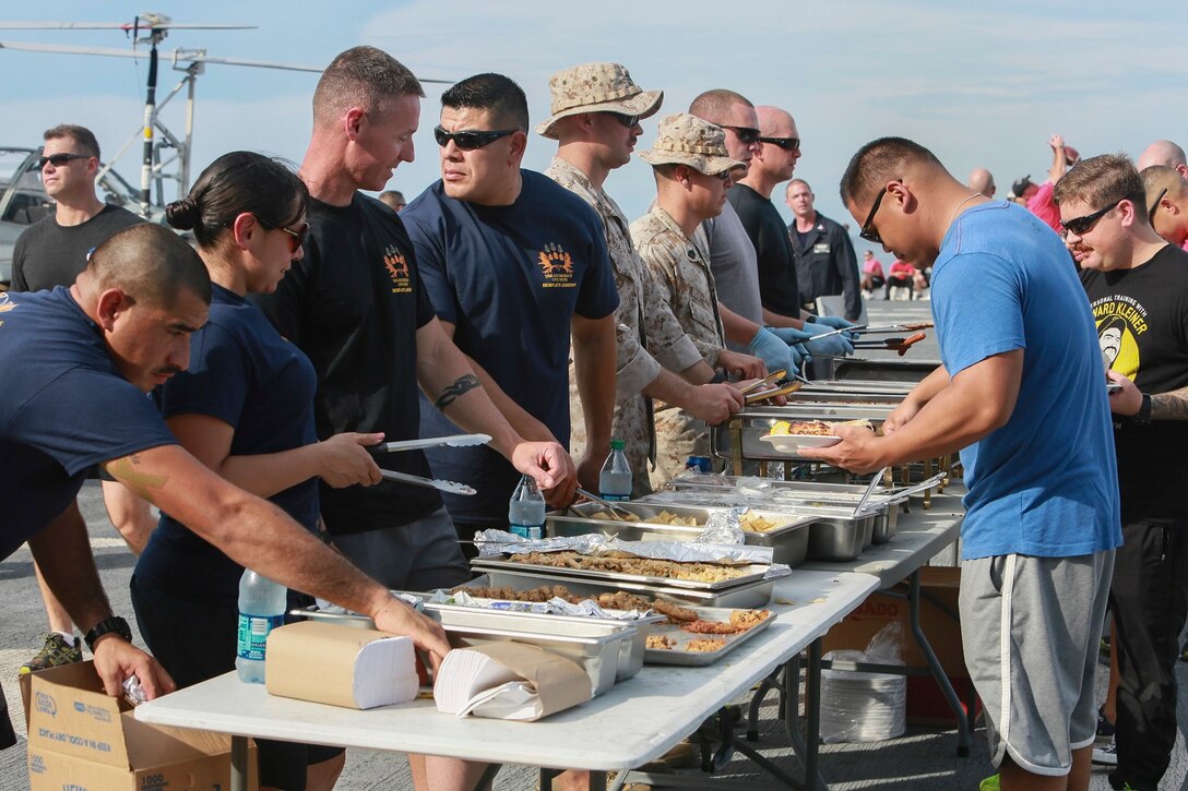 The Marines and Sailors of the 15th Marine Expeditionary Unit and USS Anchorage (LPD 23) fill their plates with food at a steel beach picnic aboard the USS Anchorage in the Philippine Sea, June 4, 2015. The Marines and Sailors of the 15th MEU and Essex Amphibious Ready Group hold such events to boost morale and build camaraderie. (U.S. Marine Corps photo by Sgt. Steve H. Lopez/Released)