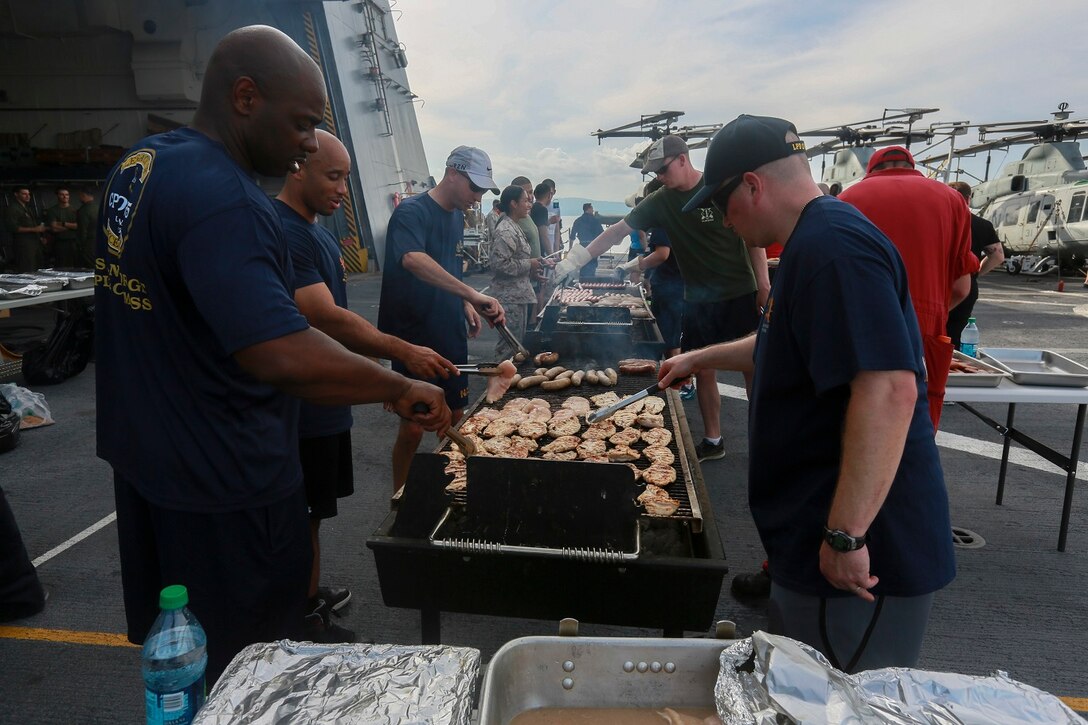 The Marines and Sailors of the 15th Marine Expeditionary Unit and USS Anchorage (LPD 23) cook on the grill at a steel beach picnic aboard the USS Anchorage in the Philippine Sea, June 4, 2015. The Marines and Sailors of the 15th MEU and Essex Amphibious Ready Group hold such events to boost morale and build camaraderie. (U.S. Marine Corps photo by Sgt. Steve H. Lopez/Released)