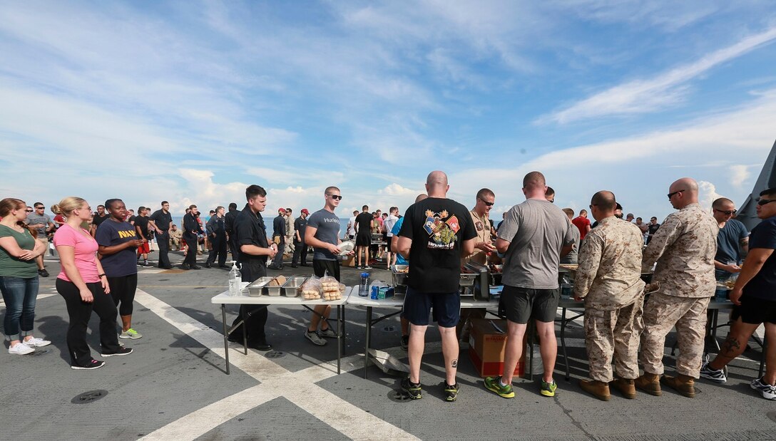 The Marines and Sailors of the 15th Marine Expeditionary Unit and USS Anchorage (LPD 23) fill their plates with food at a steel beach picnic aboard the USS Anchorage in the Philippine Sea, June 4, 2015. The Marines and Sailors of the 15th MEU and Essex Amphibious Ready Group hold such events to boost morale and build camaraderie. (U.S. Marine Corps photo by Sgt. Steve H. Lopez/Released)